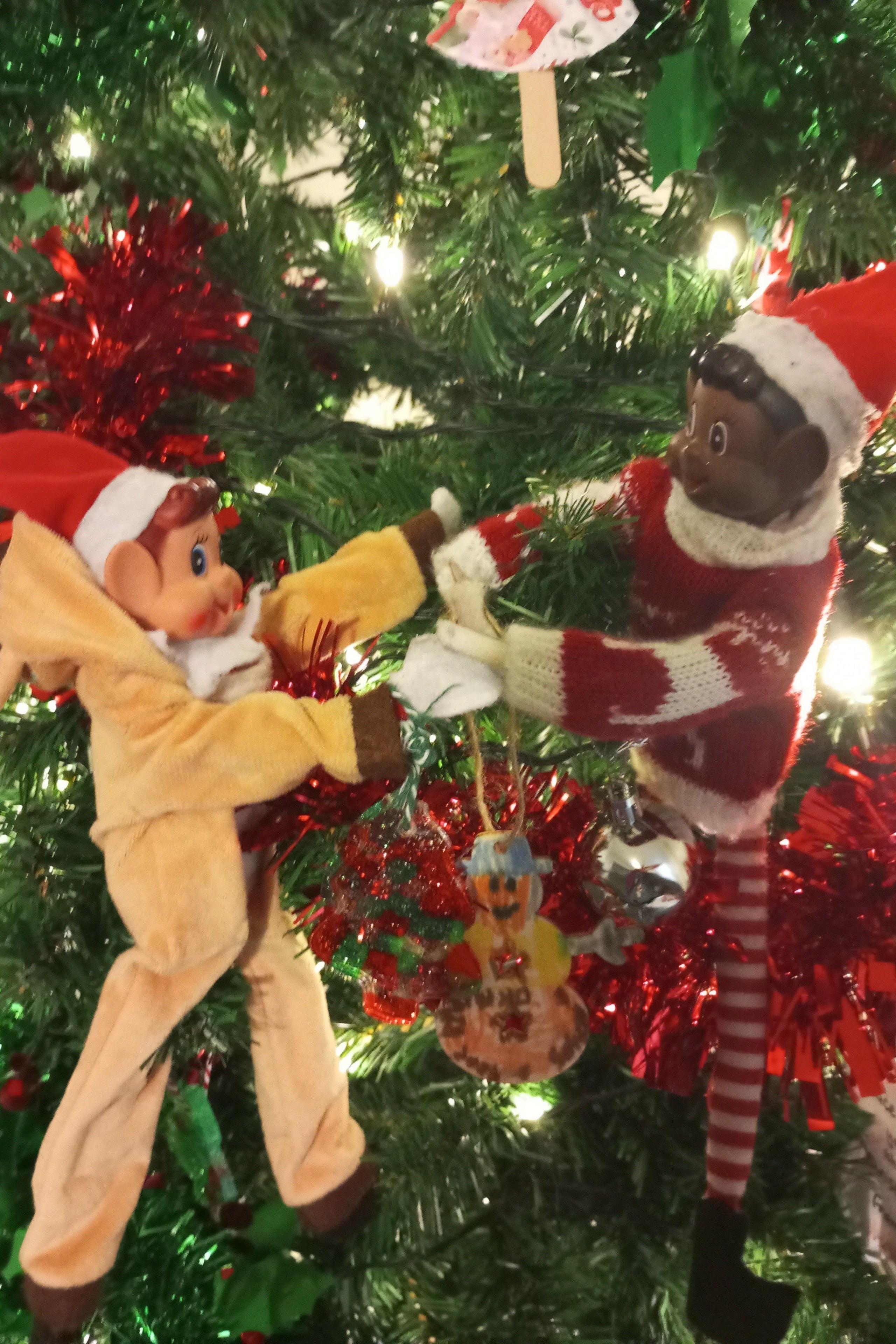 Two plastic Christmas elves on a Christmas tree 