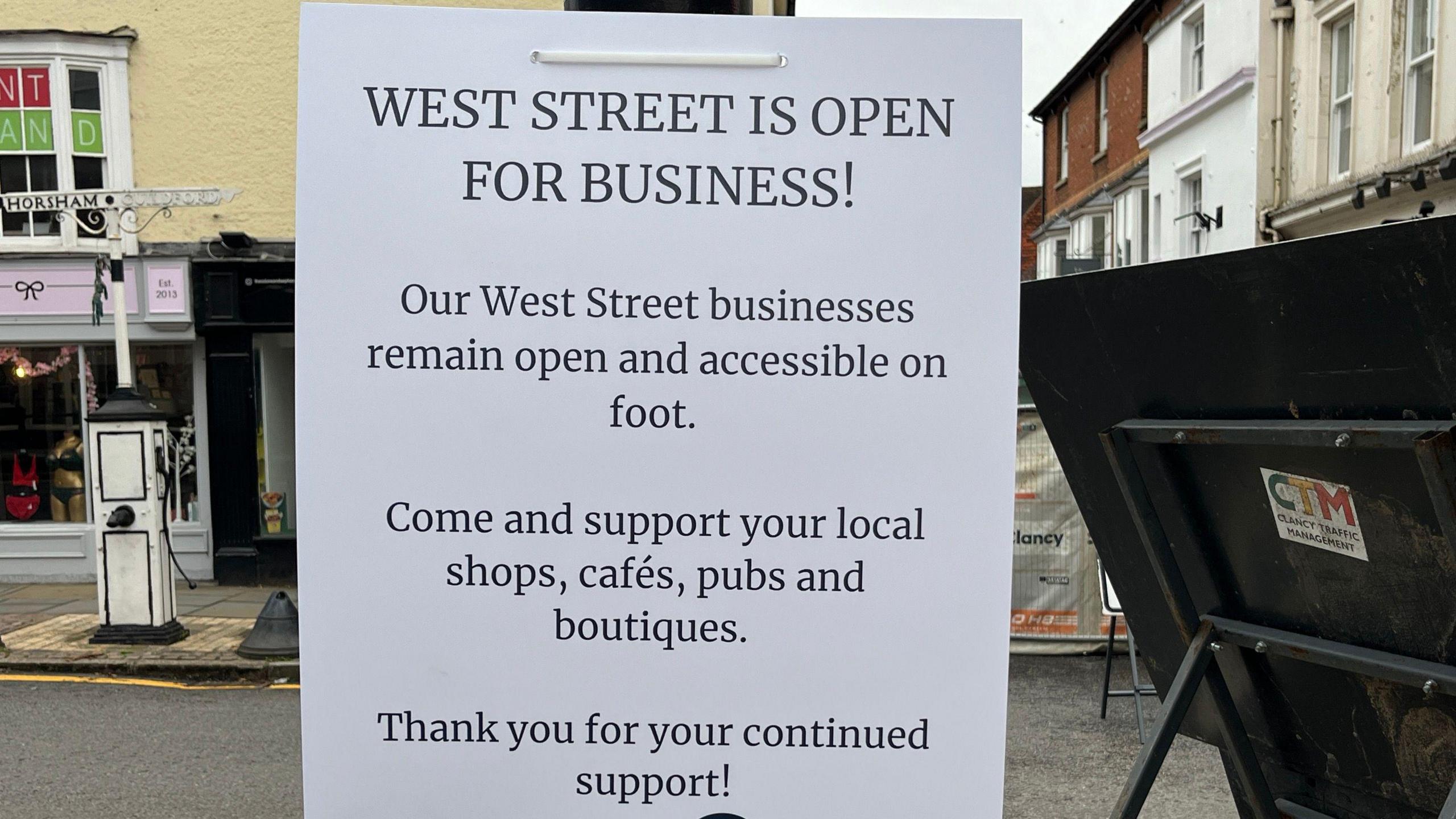 A poster put up in Dorking reminds shoppers that West street is open for business during the repair work