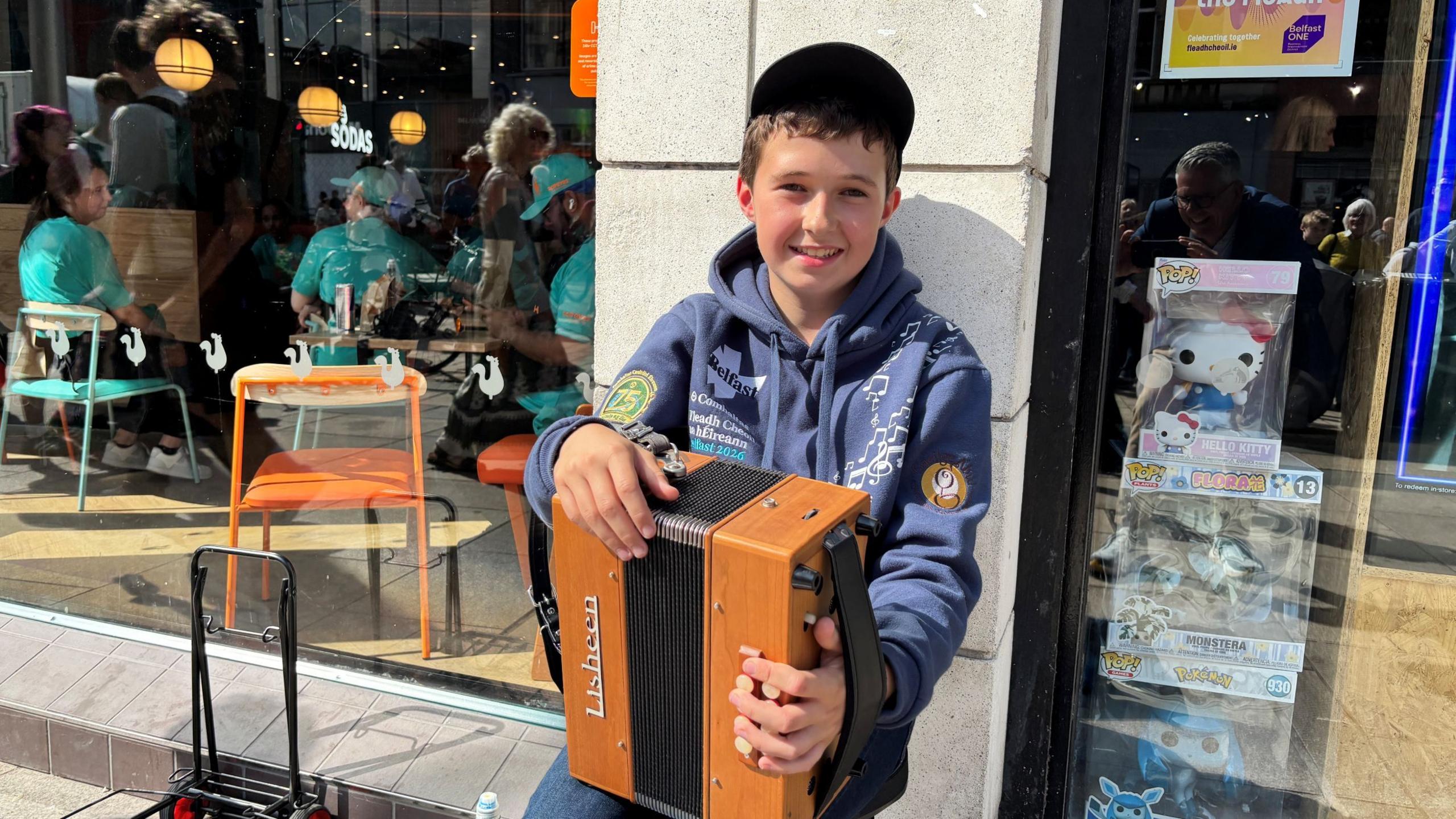 Boy holding a brown accordion
