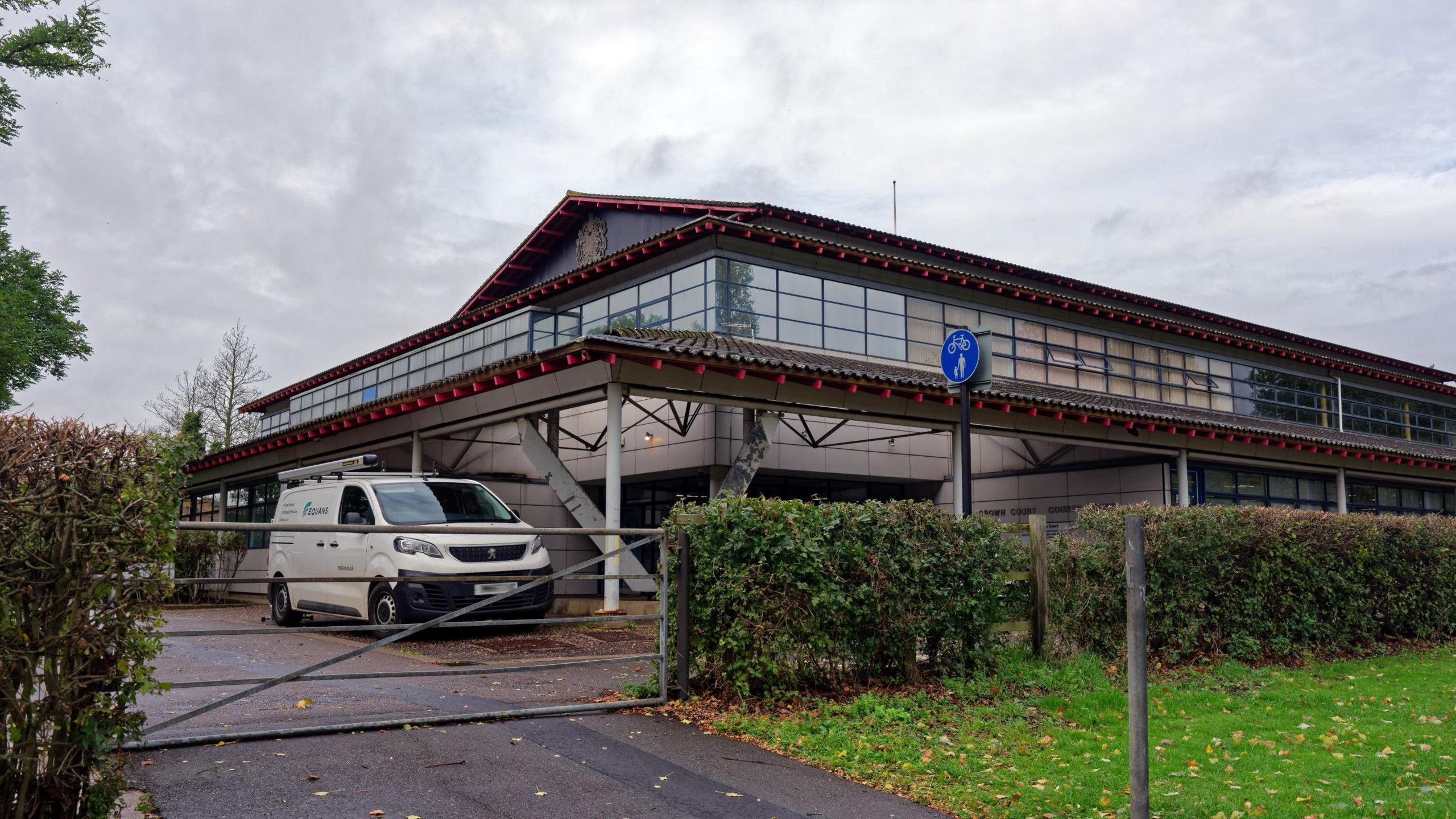 Outside the crown court building with driveway and gate 