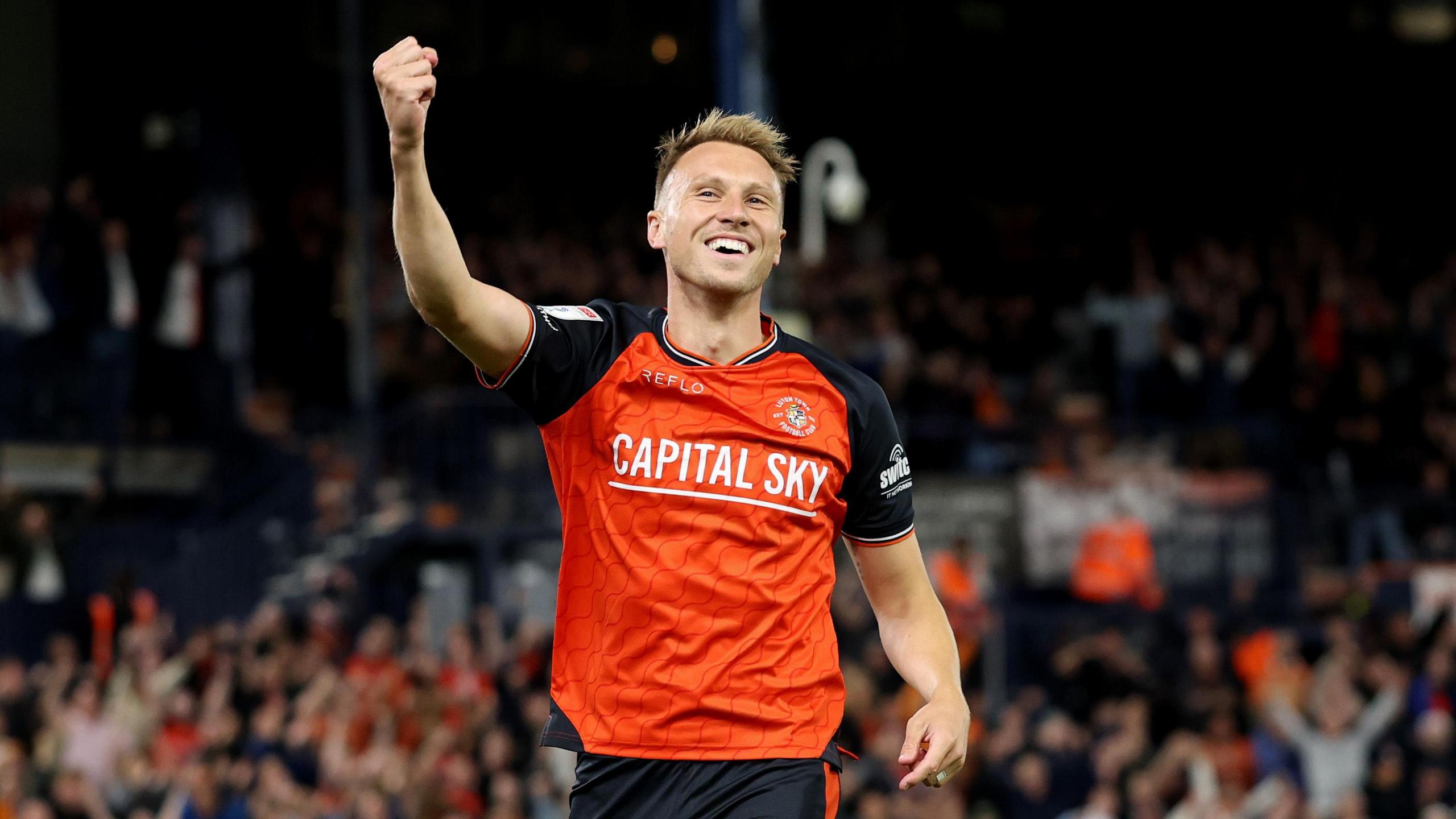 Cauley Woodrow smiles and holds his arm in the air with a fist clenched