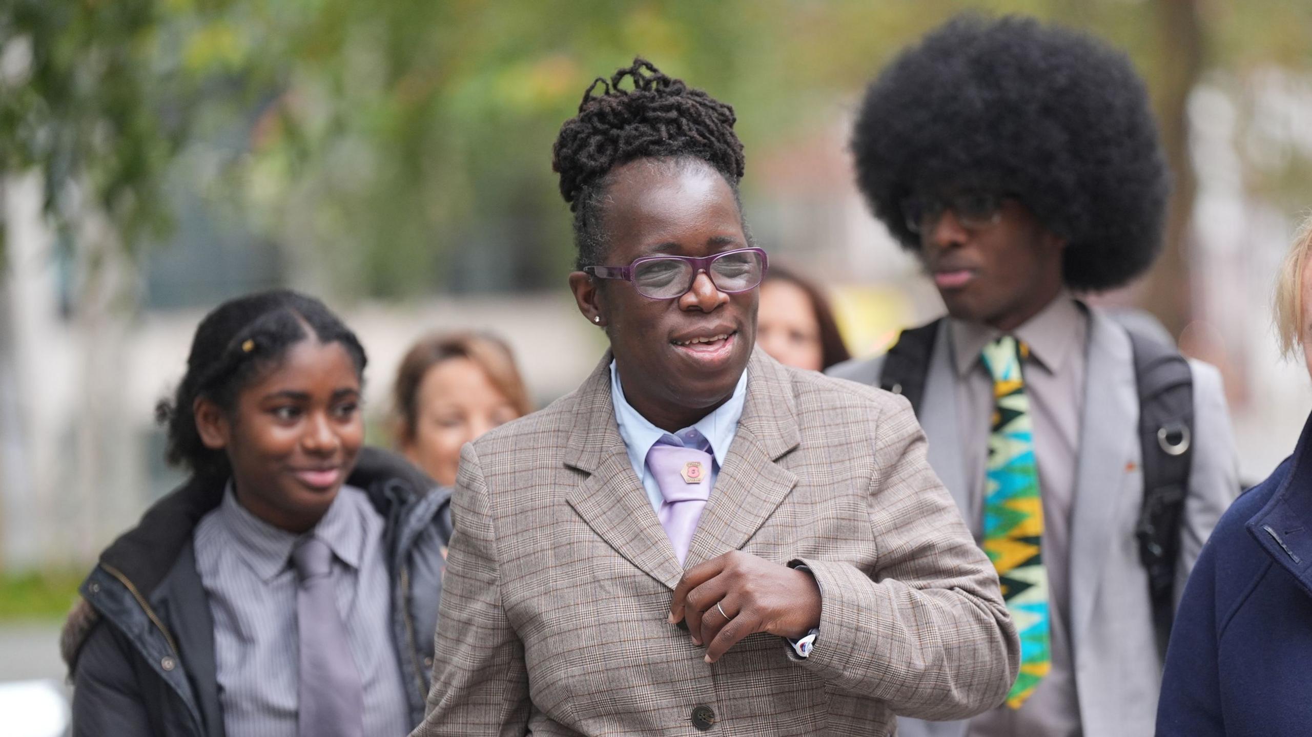 Ms Adoo-Kissi-Debrah leaving the offices of Department for Environment, Food and Rural Affairs. Behind her are a young girl and a boy in a colourful tie.