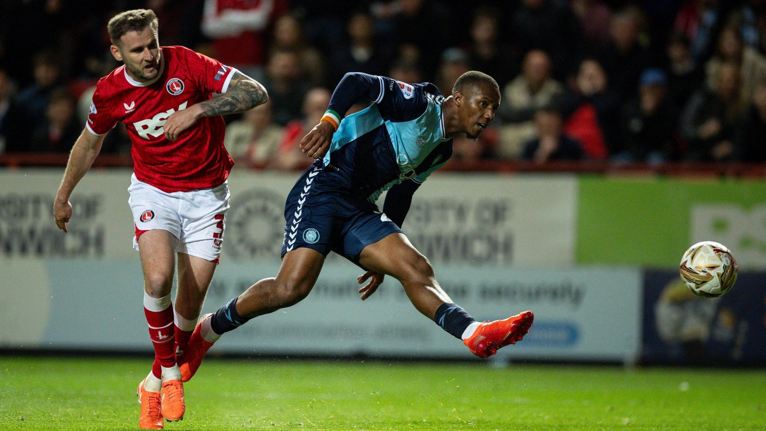 Richard Kone takes a shot for Wycombe Wanderers under a challenge from Charlton Athletic's Macaulay Gillesphey