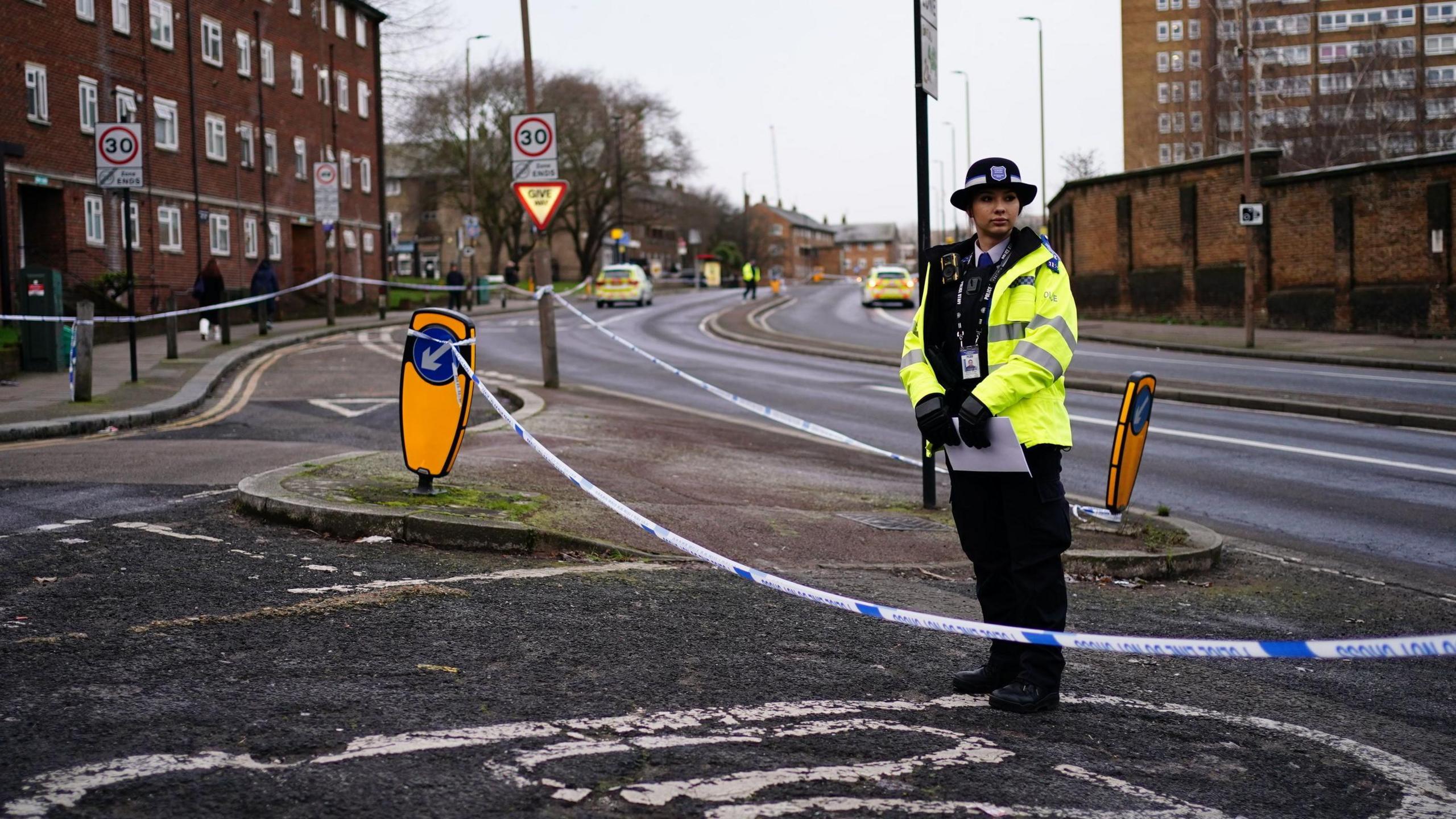 A police officer inside a police cordon on Woolwich Church Road in Woolwich