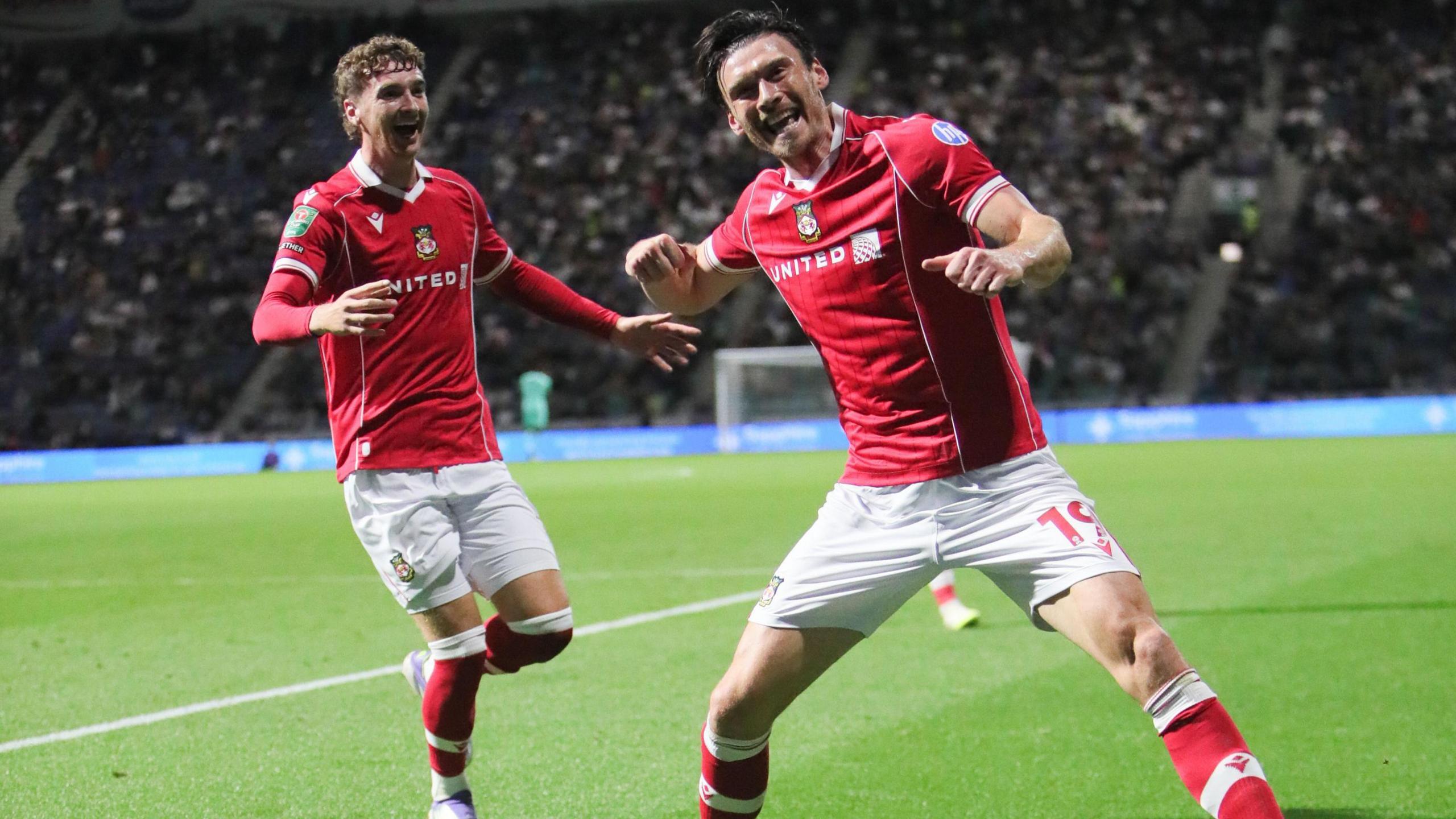 Kieffer Moore prepares to punch the air in celebration after scoring for Wrexham 