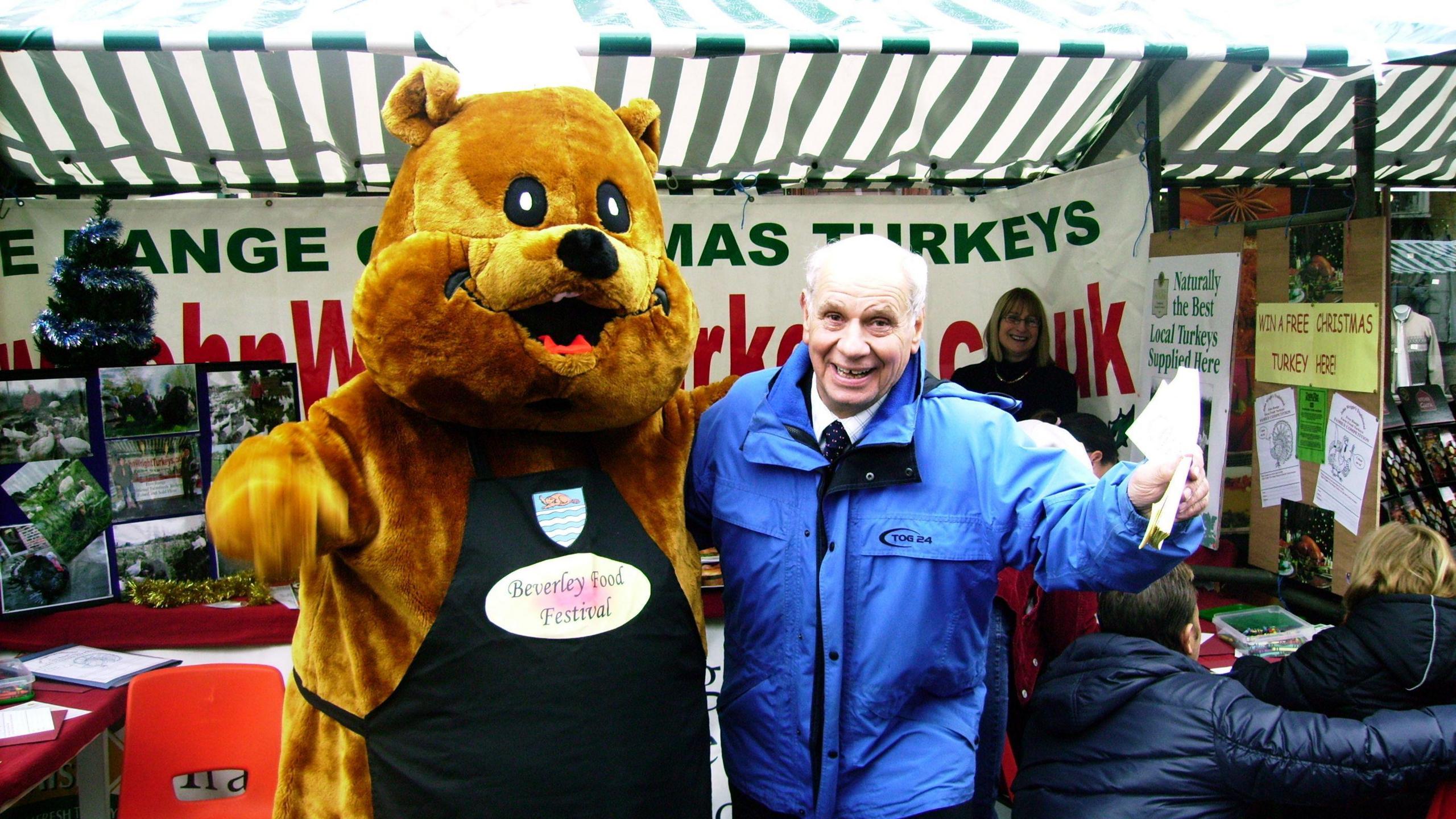 An archive image showing John Wright Snr standing in front of a stall which is taking bookings for Christmas turkeys