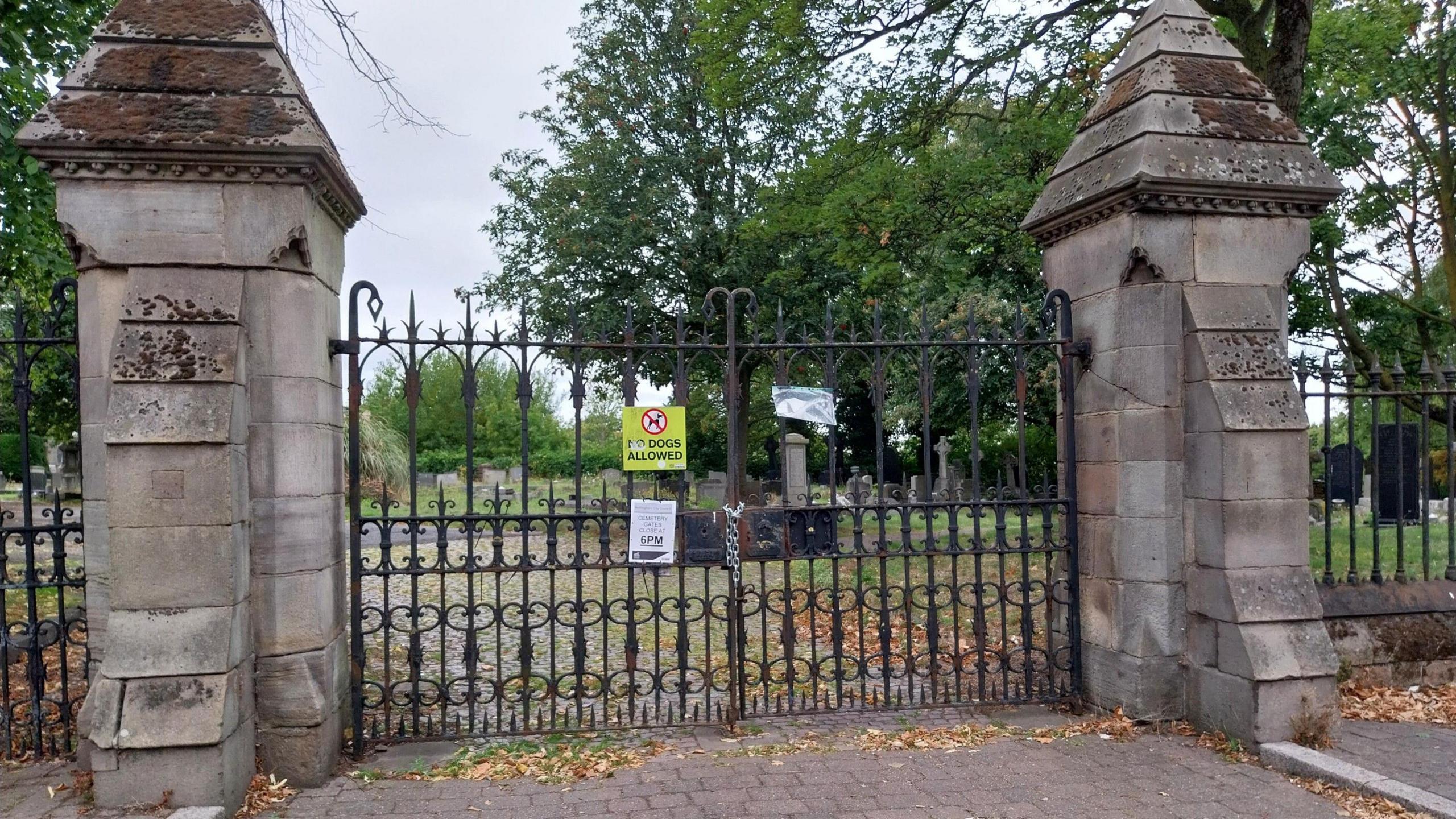 The cemetery gates with a lock around them and a note explaining the reason for the closure