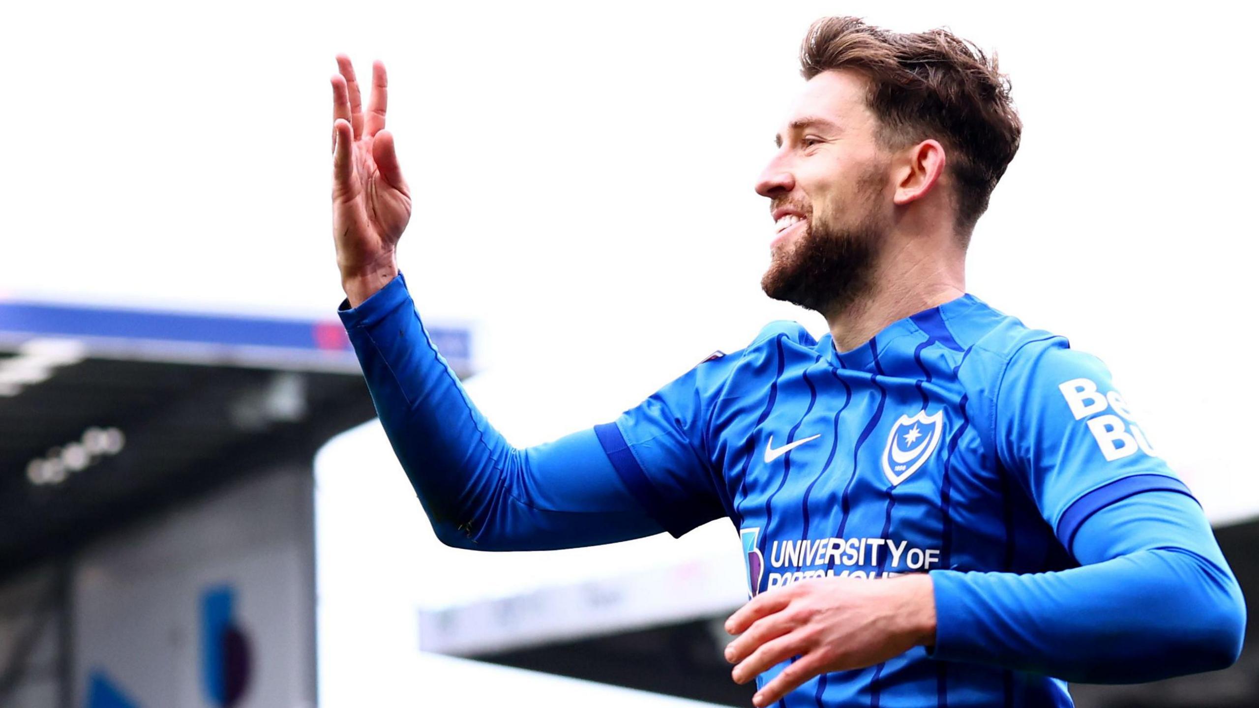 Portsmouth's Callum Lang holds up four fingers after scoring four goals against Coventry