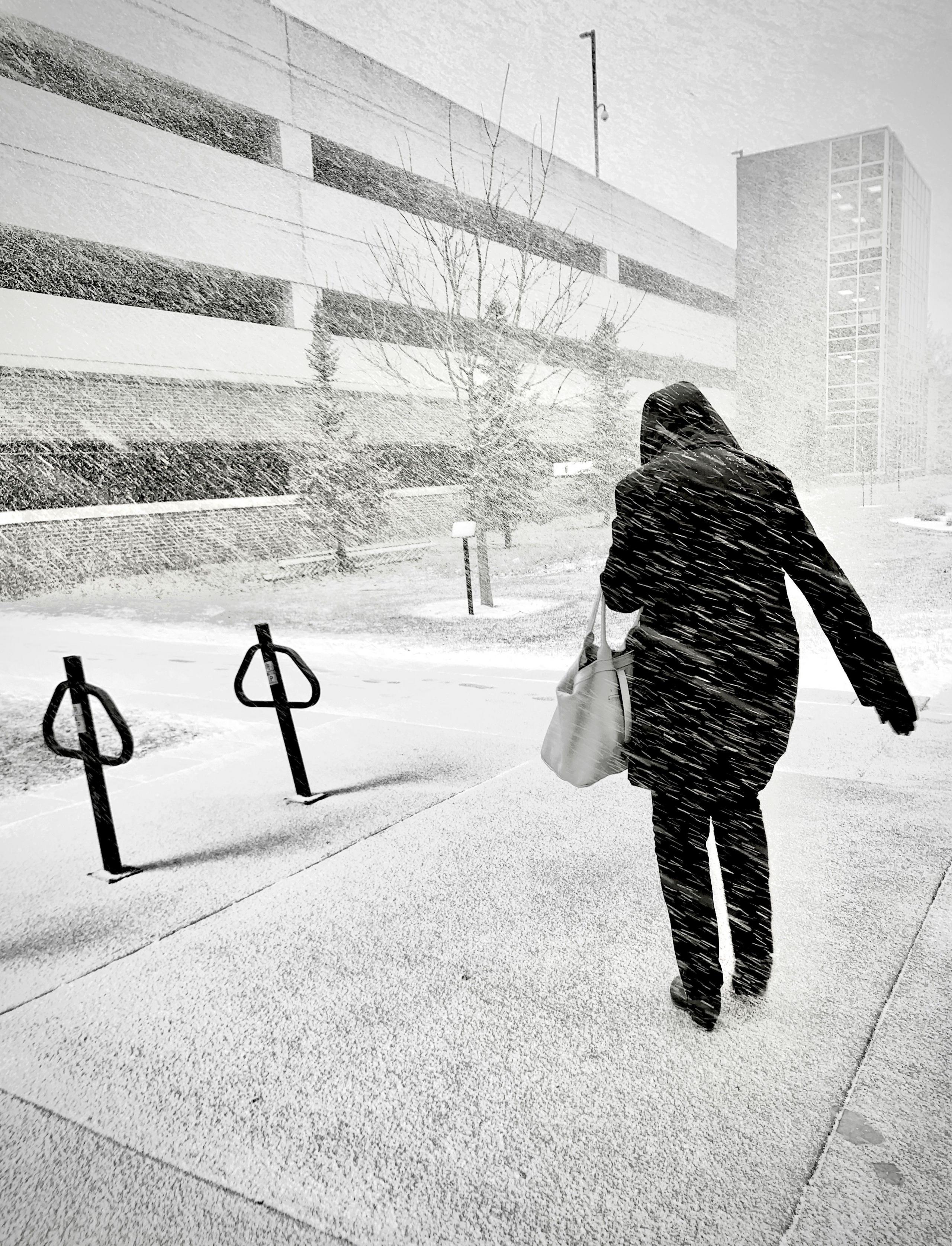 A woman walks against snow being driven by wind in Wisconsin