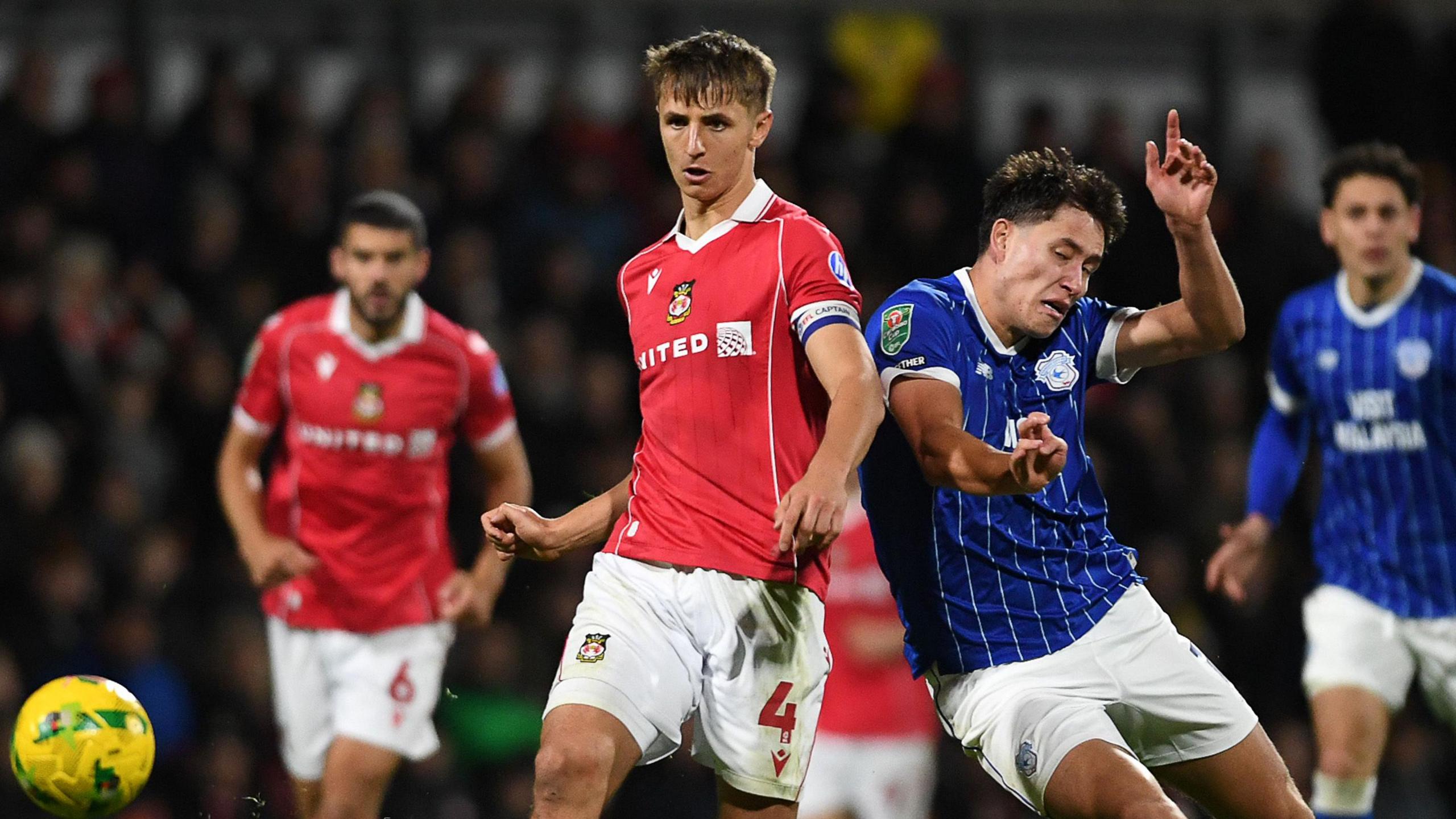 Max Cleworth of Wrexham is challenged by Rubin Colwill of Cardiff City in an EFL Cup tie last season