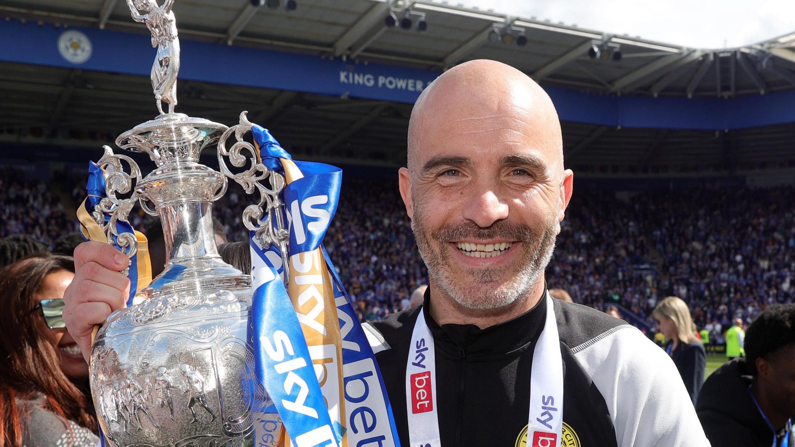 A close up picture of Enzo Maresca who is holding the Championship trophy