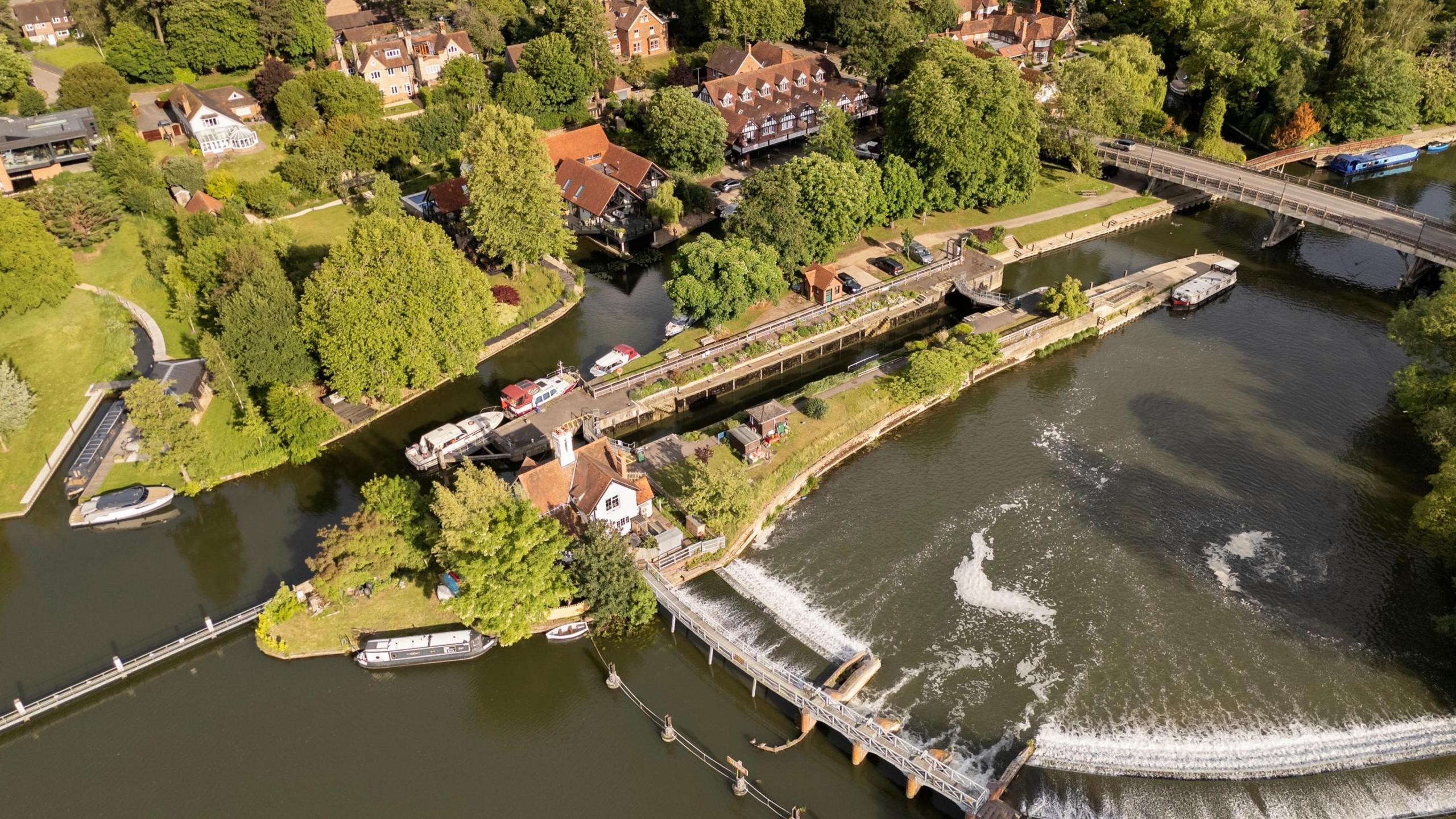 An aerial shot of the boathouse, with other buildings and the wider river visible.