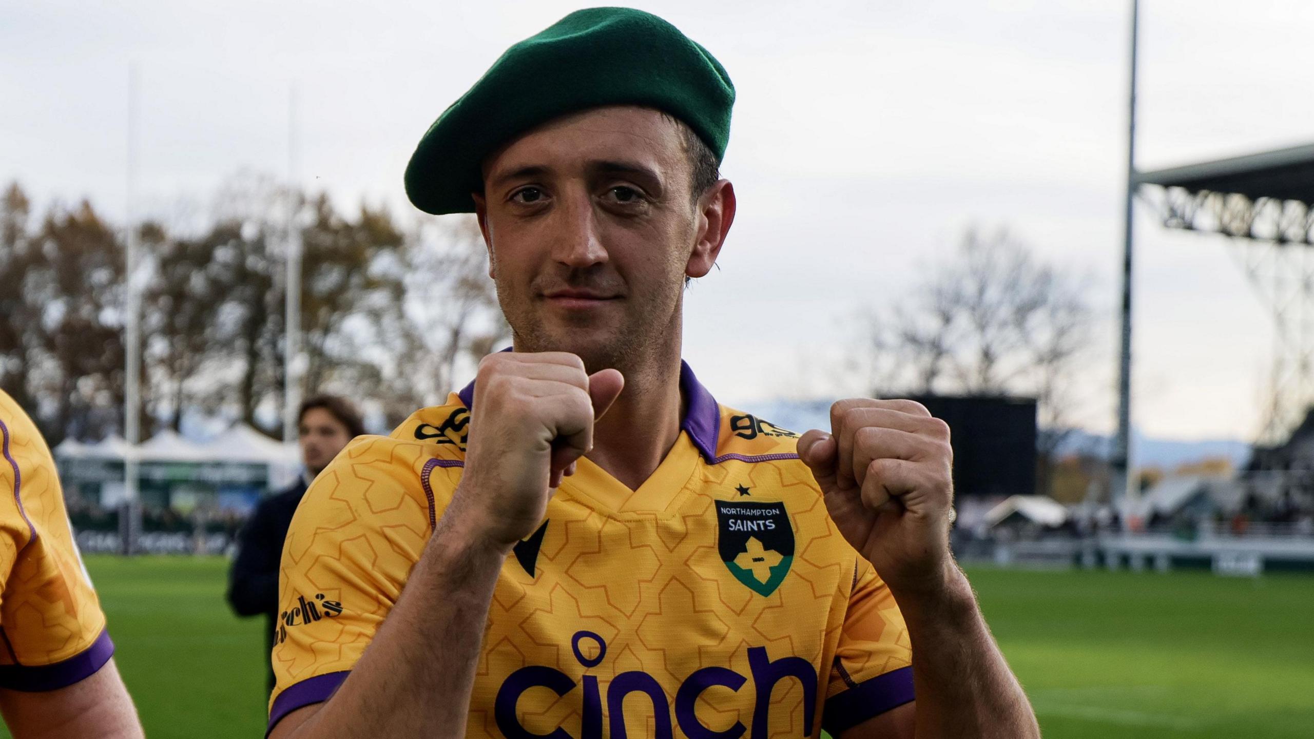 Northampton Saints scrum-half Alex Mitchell with both fists clenched in celebration and wearing a beret following their Champions Cup win in Pau