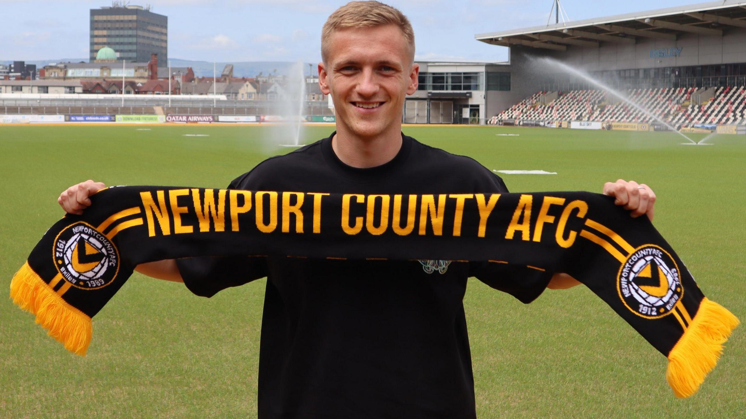 Matt Smith holds up a Newport scarf