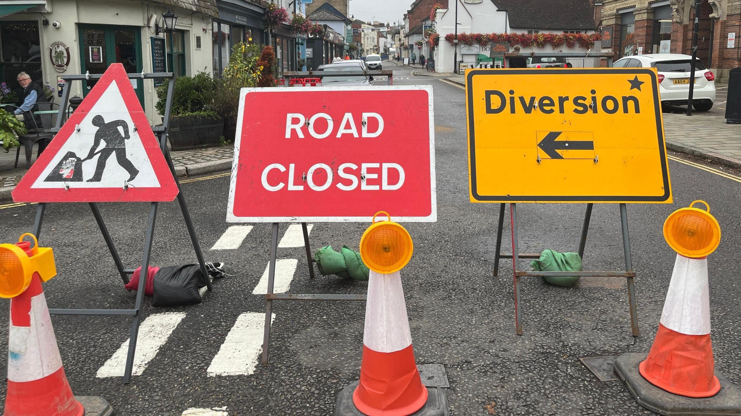 Signs saying road closed and diversion with cones in the foreground