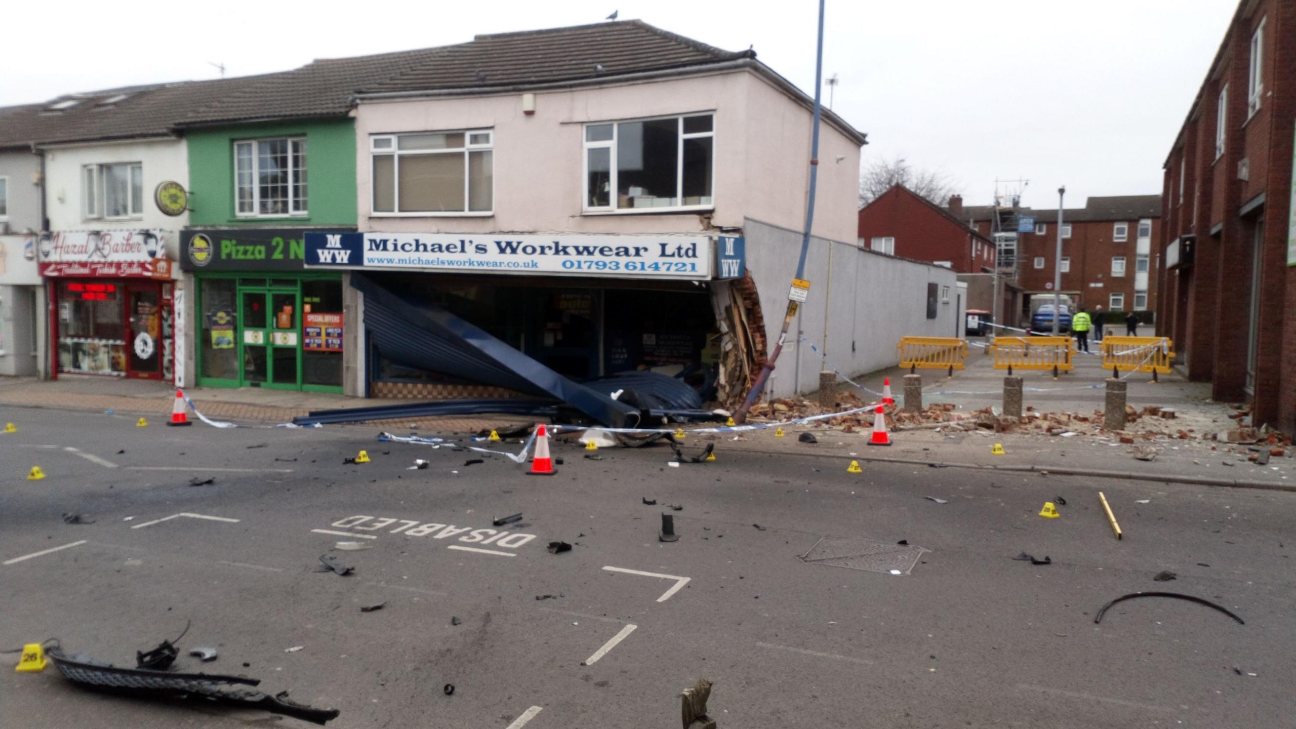 Michael's Workwear after the crash with the shop front destroyed and debris on the ground