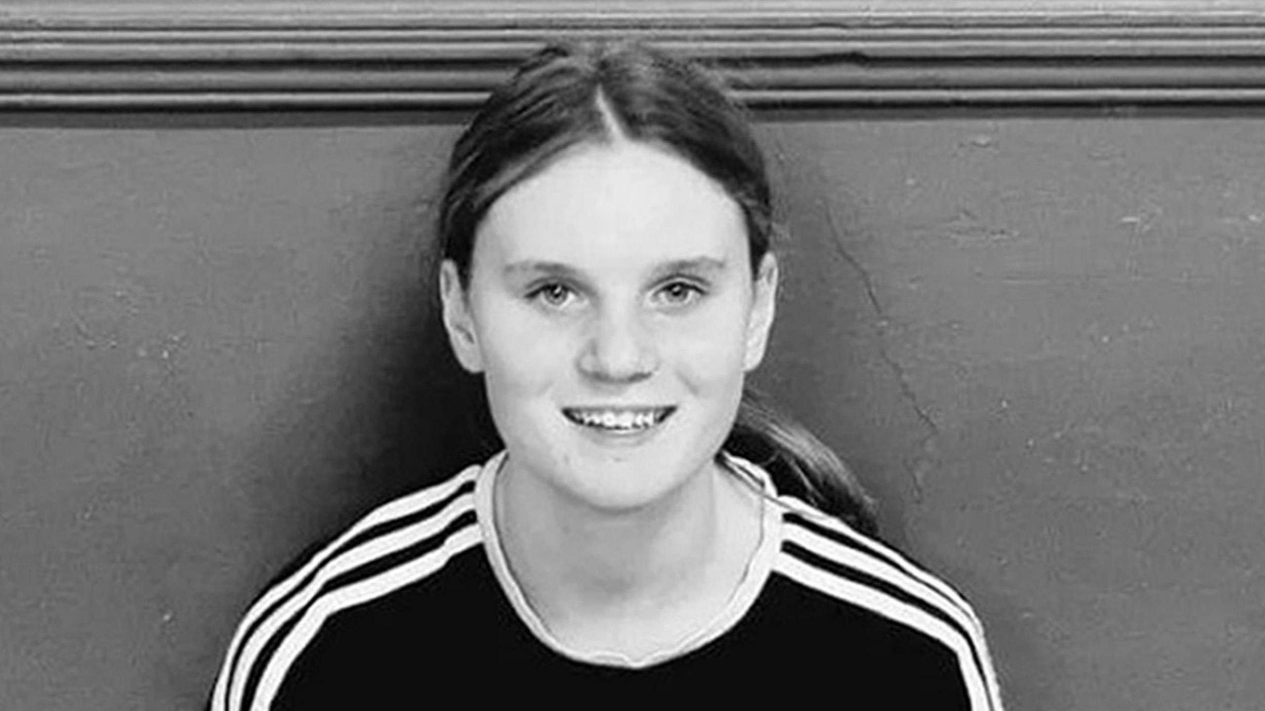 Black and white picture of a teenage girl with long hair in a pony tail