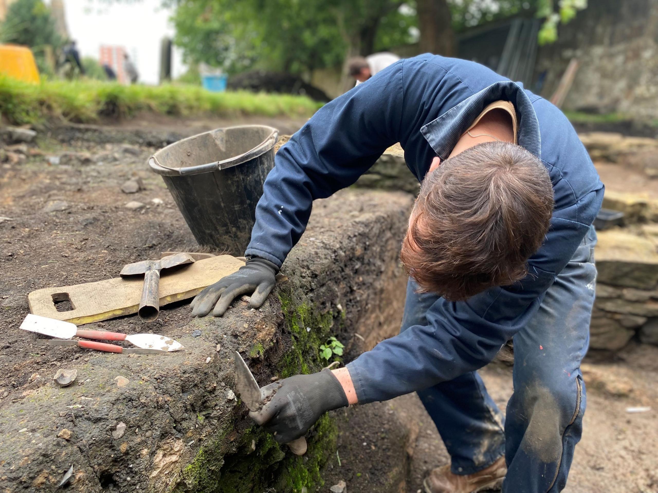 A man excavates part of the churchyard