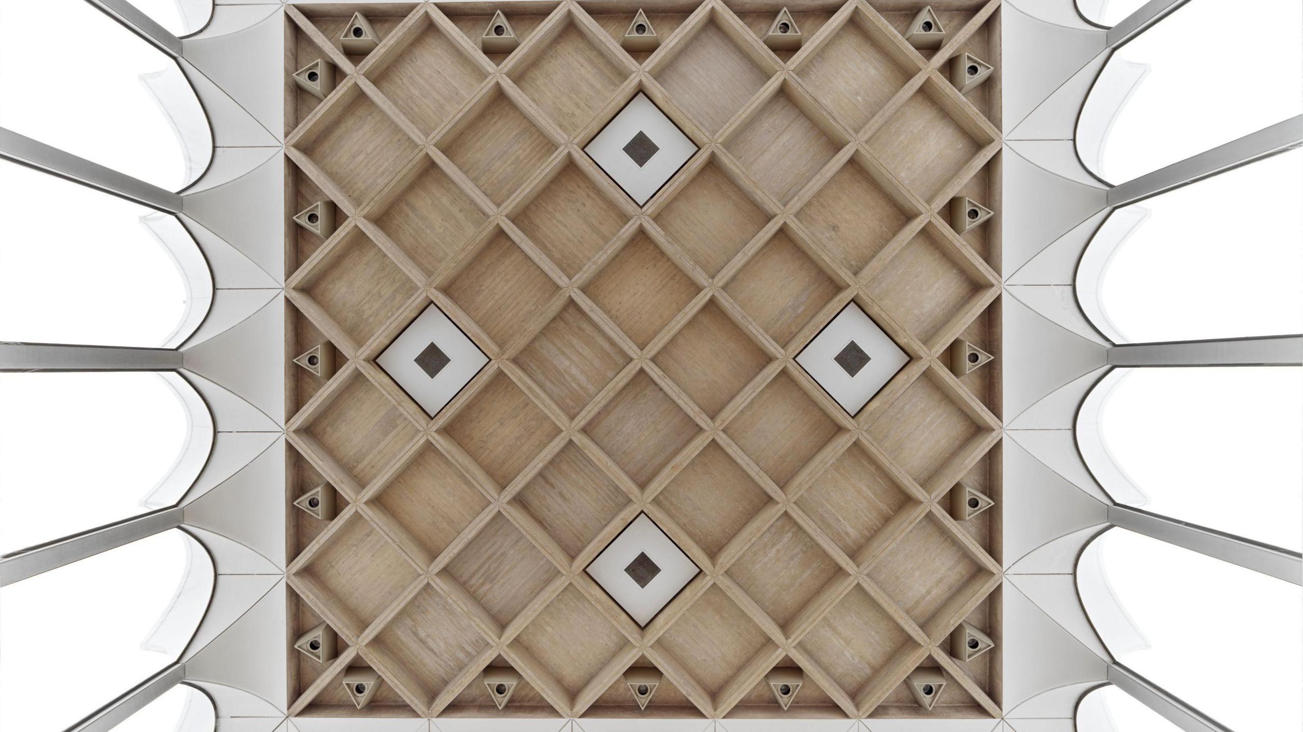 A view of the 1960s ceiling of a dining hall showing a grid of concrete ribs and arched windows,  Fitzwilliam College, Cambridge