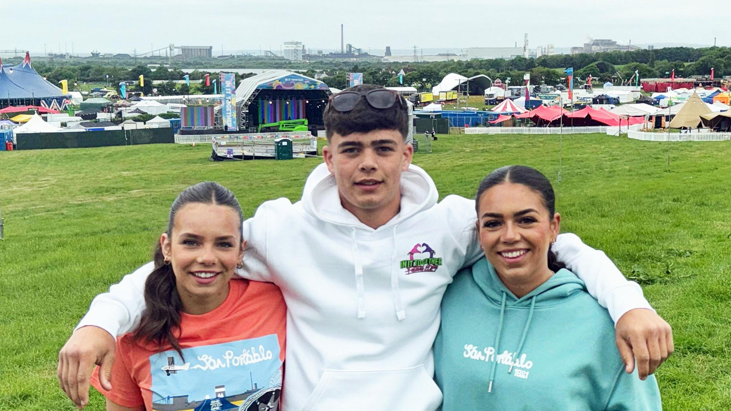 Three Williams siblings, Phoebe, Charlie and May in front of the festival on the family farm in Margam