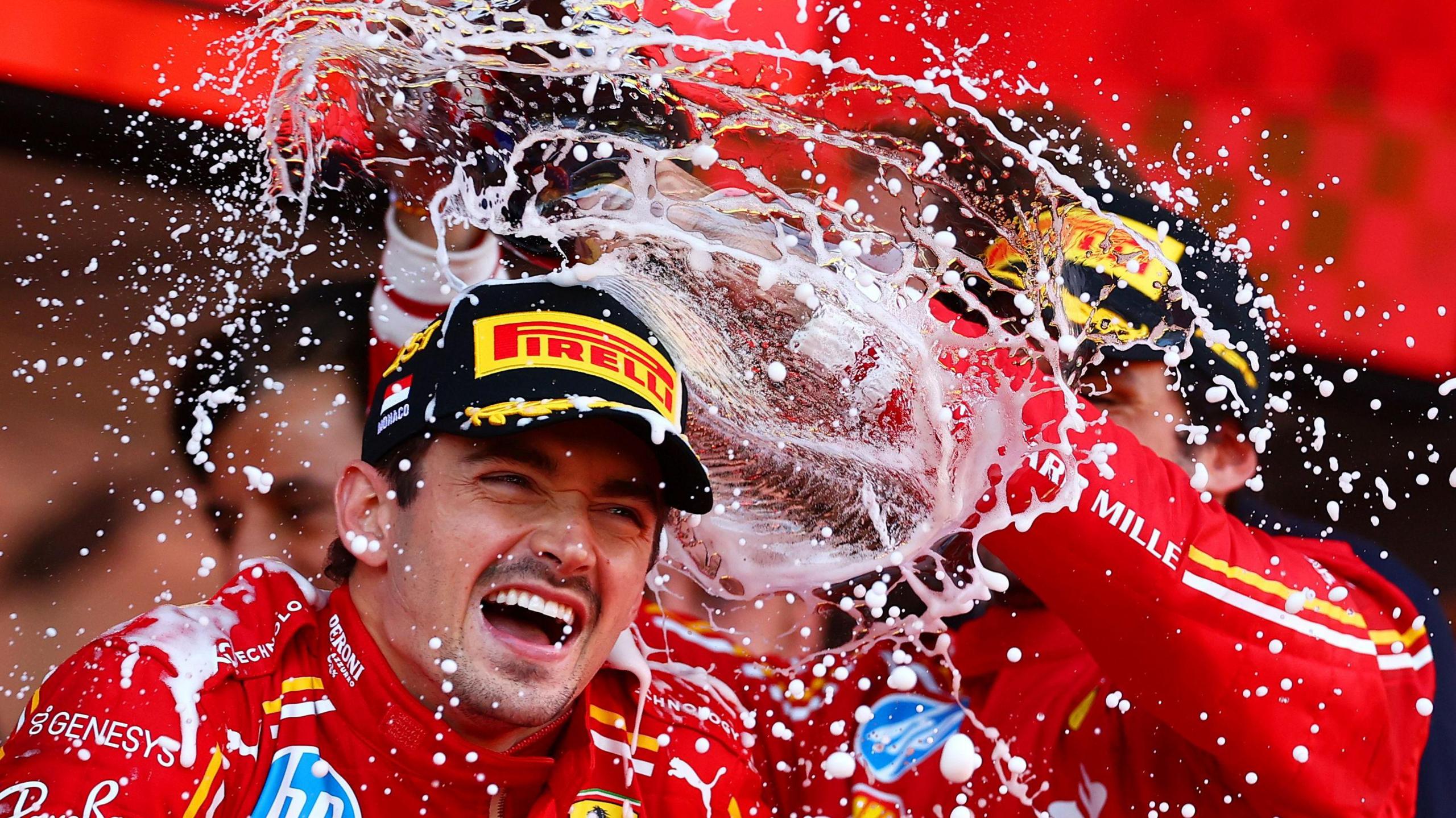 Race winner Charles Leclerc is drenched in Champagne by Ferrari team-mate Carlos Sainz after winning his home race in 2024