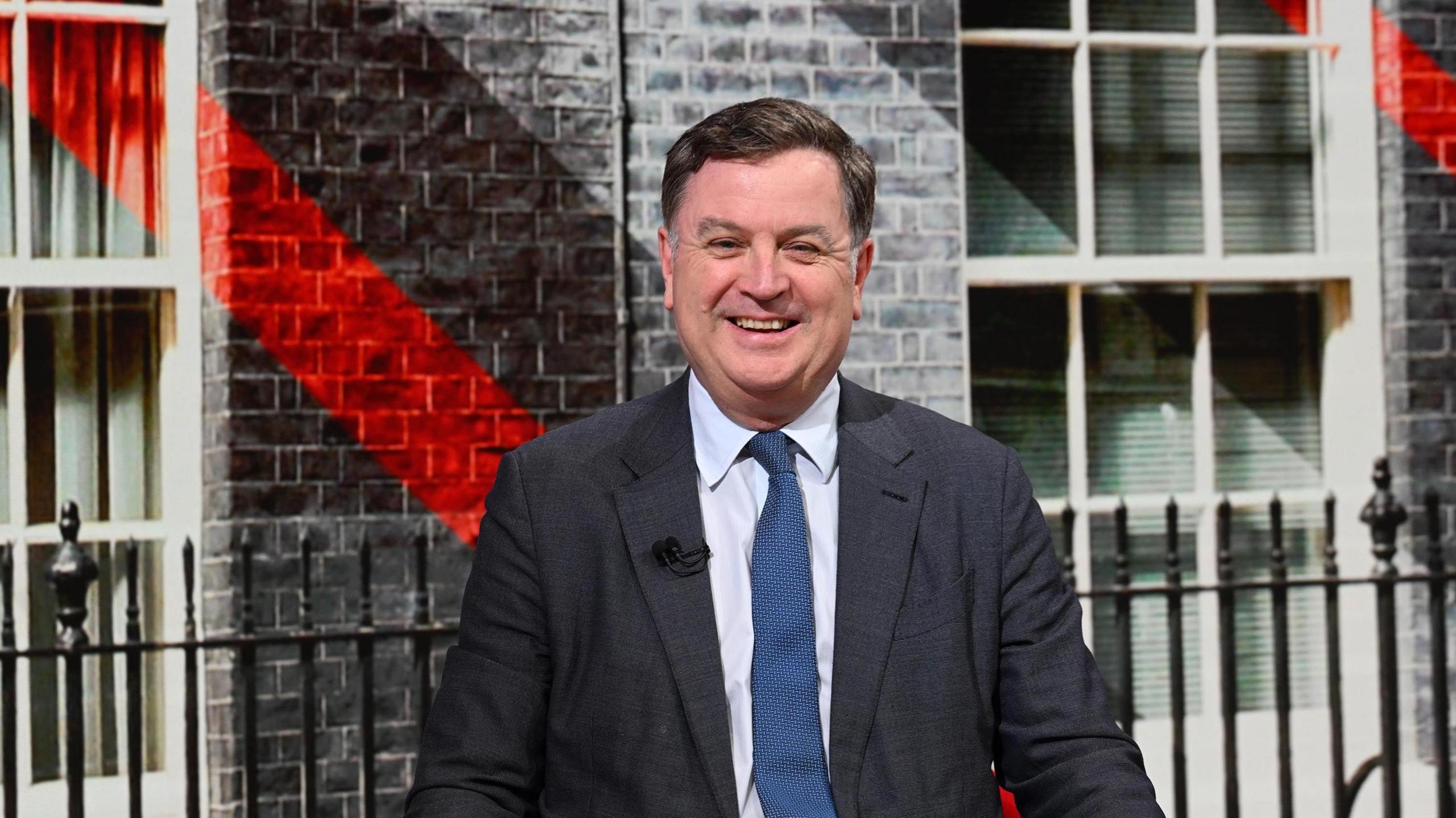 Mel Stride wearing a suit and tie against a background of Downing street