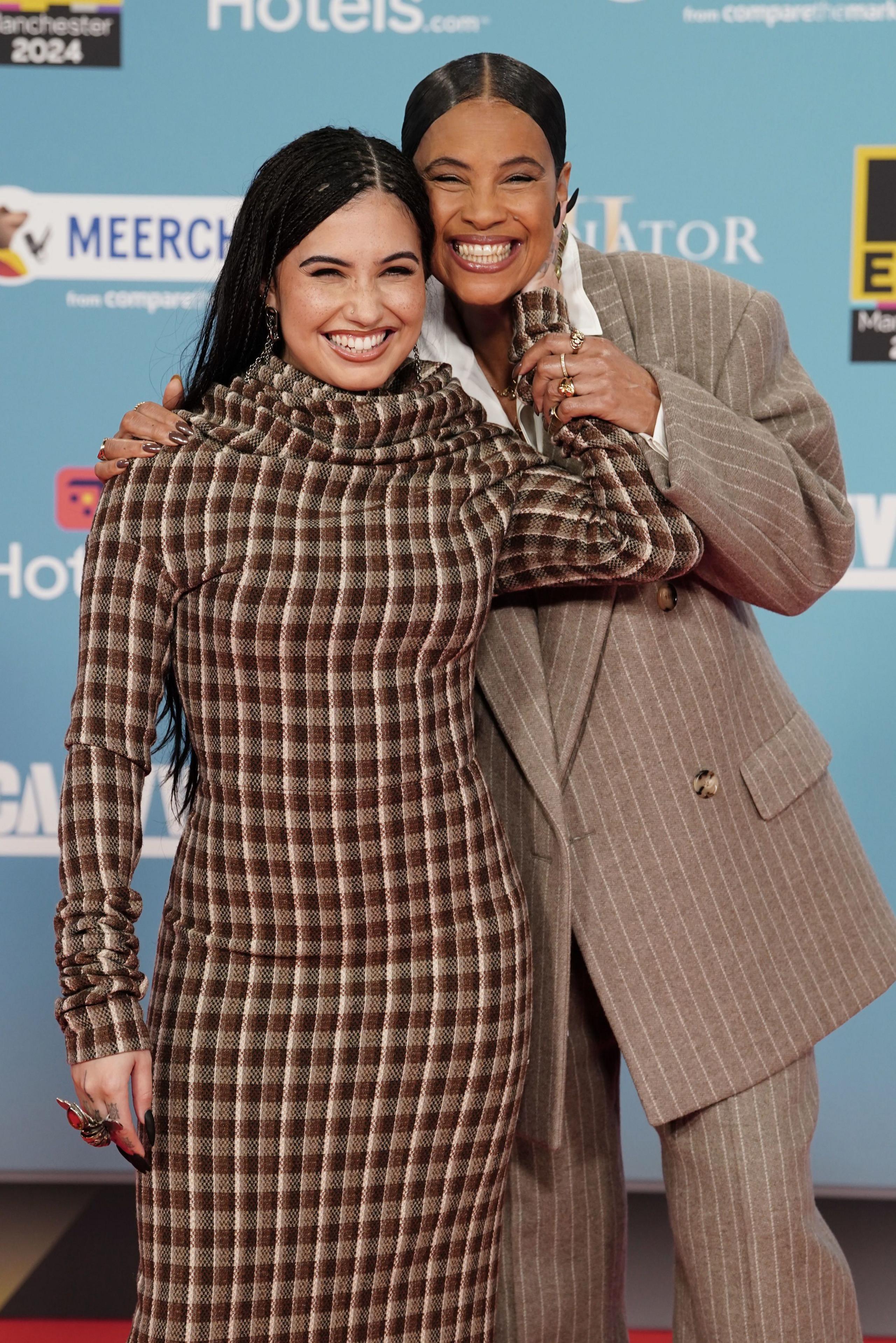 Mabel and Neneh Cherry standing together smiling broadly with their heads together and holding each other