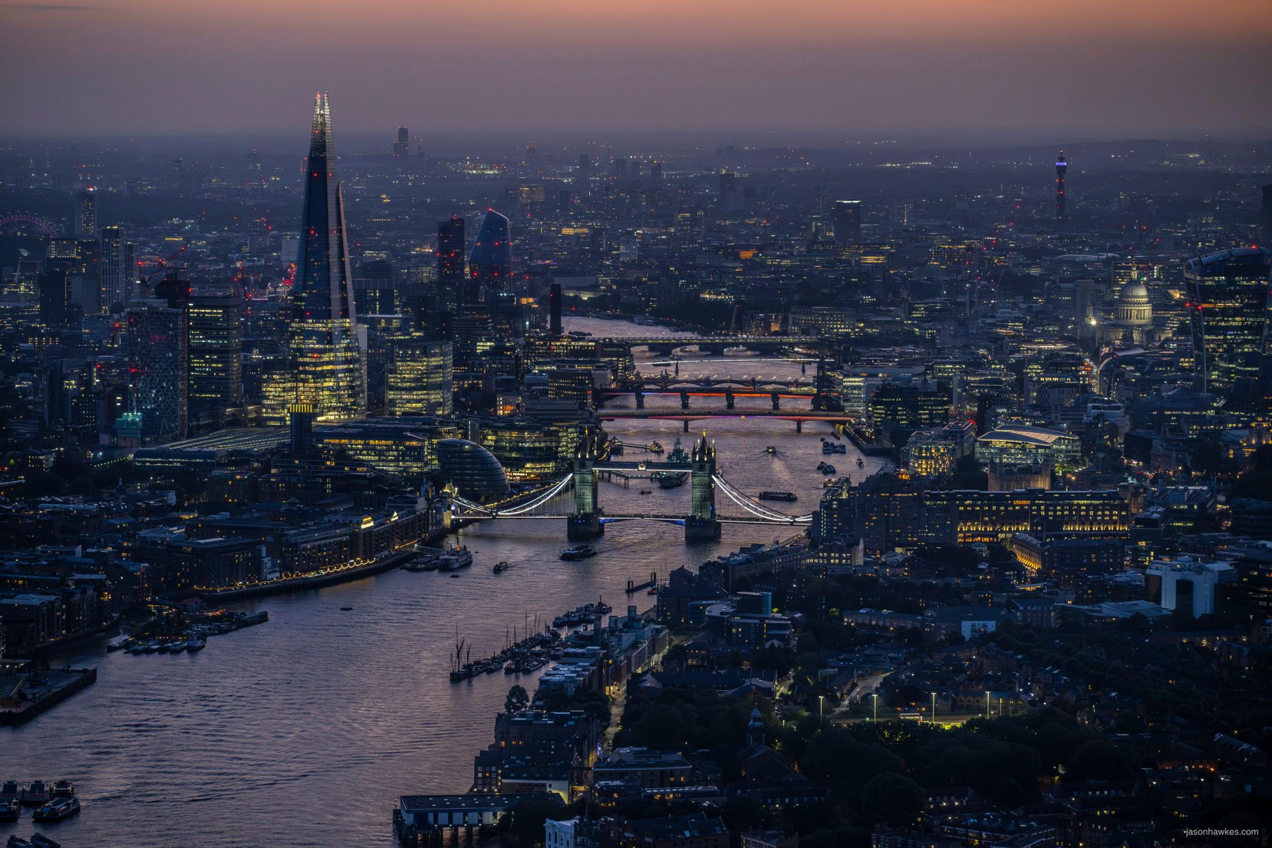 Night falls over River Thames, showing Tower Bridge in foreground and Shard and City of London in background