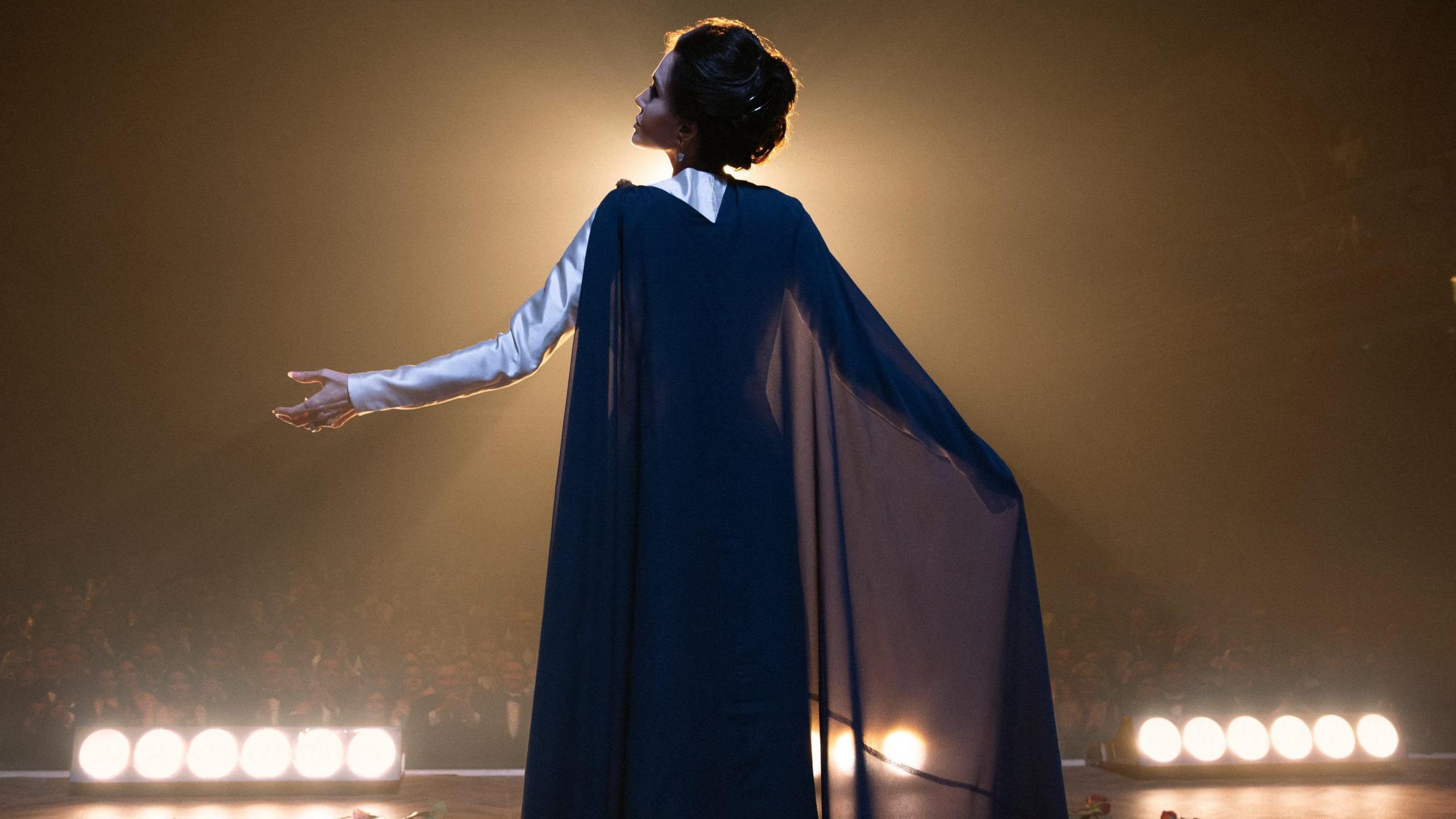 Angelina Jolie in Maria, pictured singing to an audience in a theatre