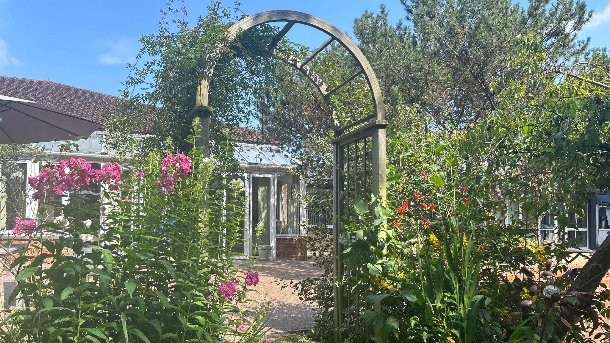 Flowery arch at revamped garden outside palliative care unit in Nottingham