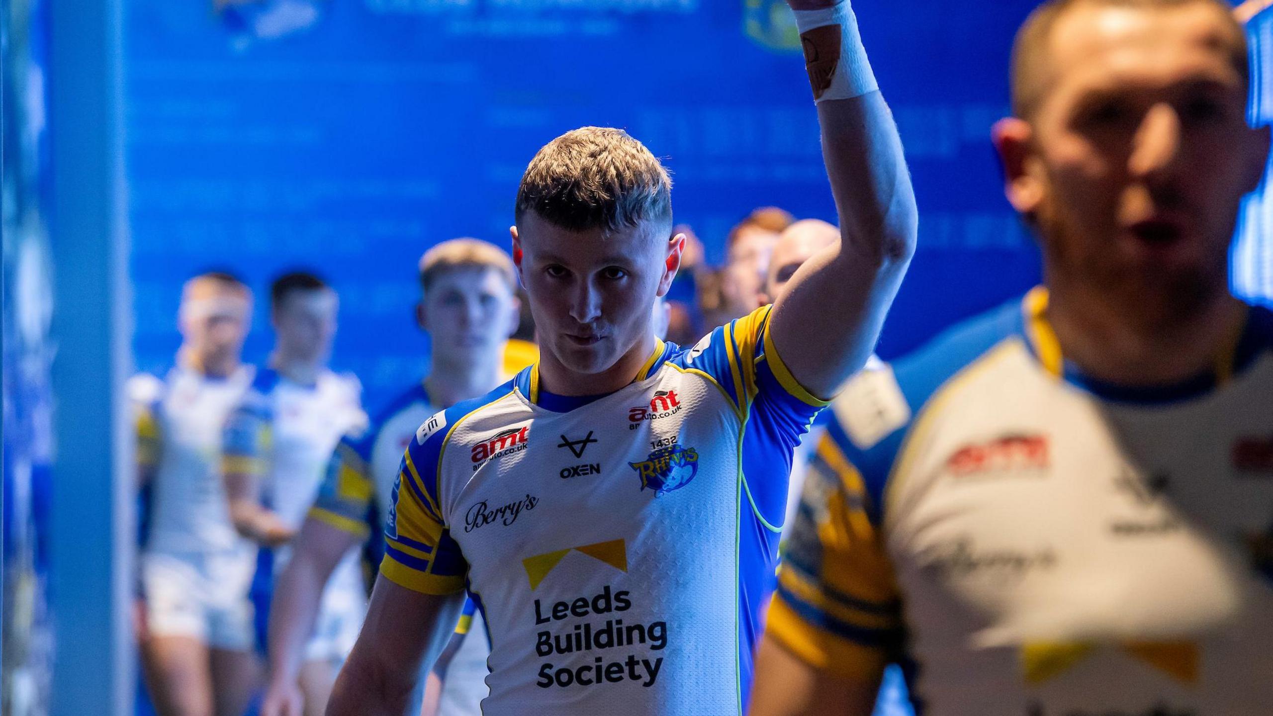 Harry Newman reaches up to touch the rhino's head which is positioned just before the teams come out of the tunnel