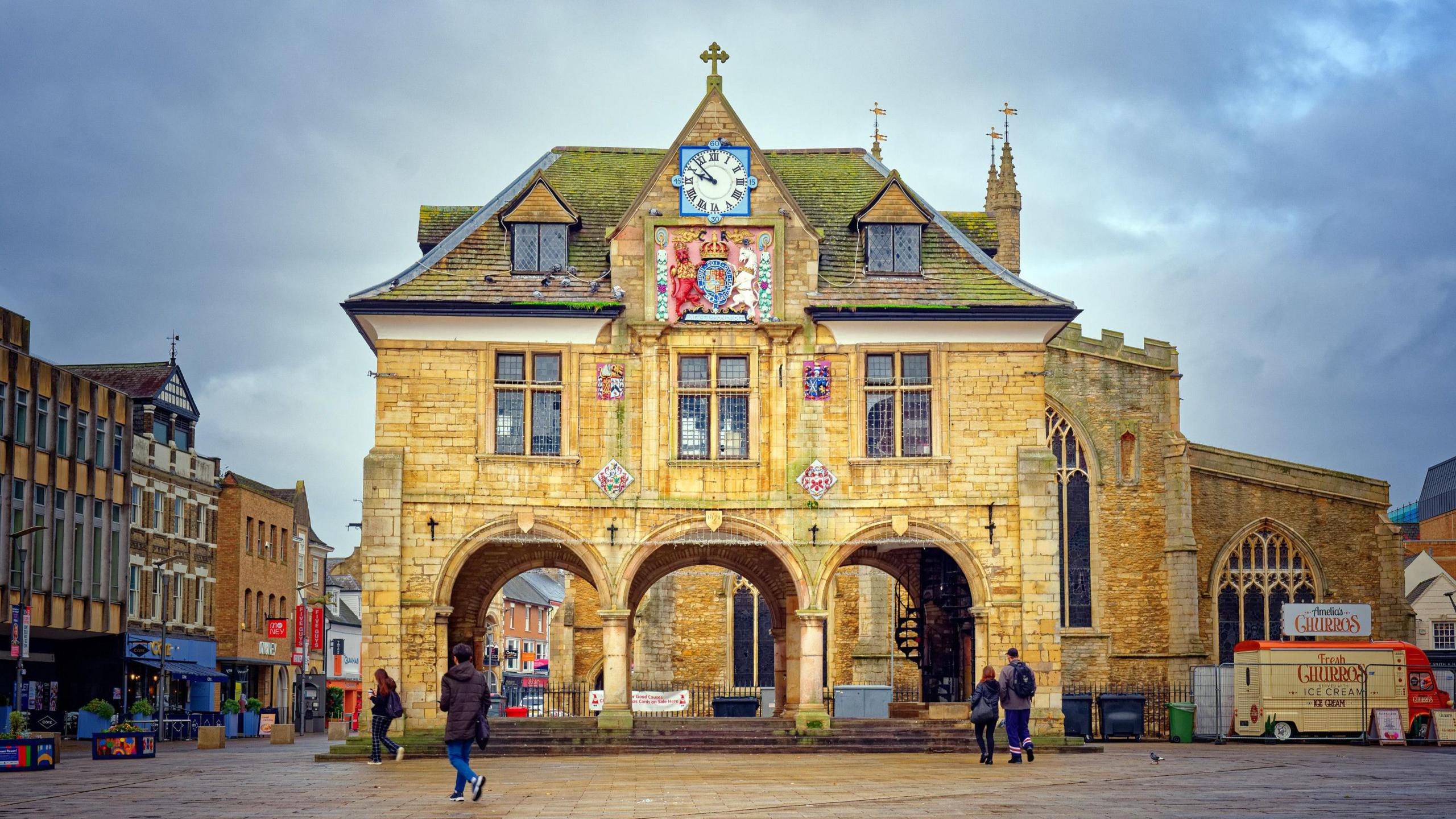 Peterborough's Cathedral Square - there are people wandering around the Old Market Hall.