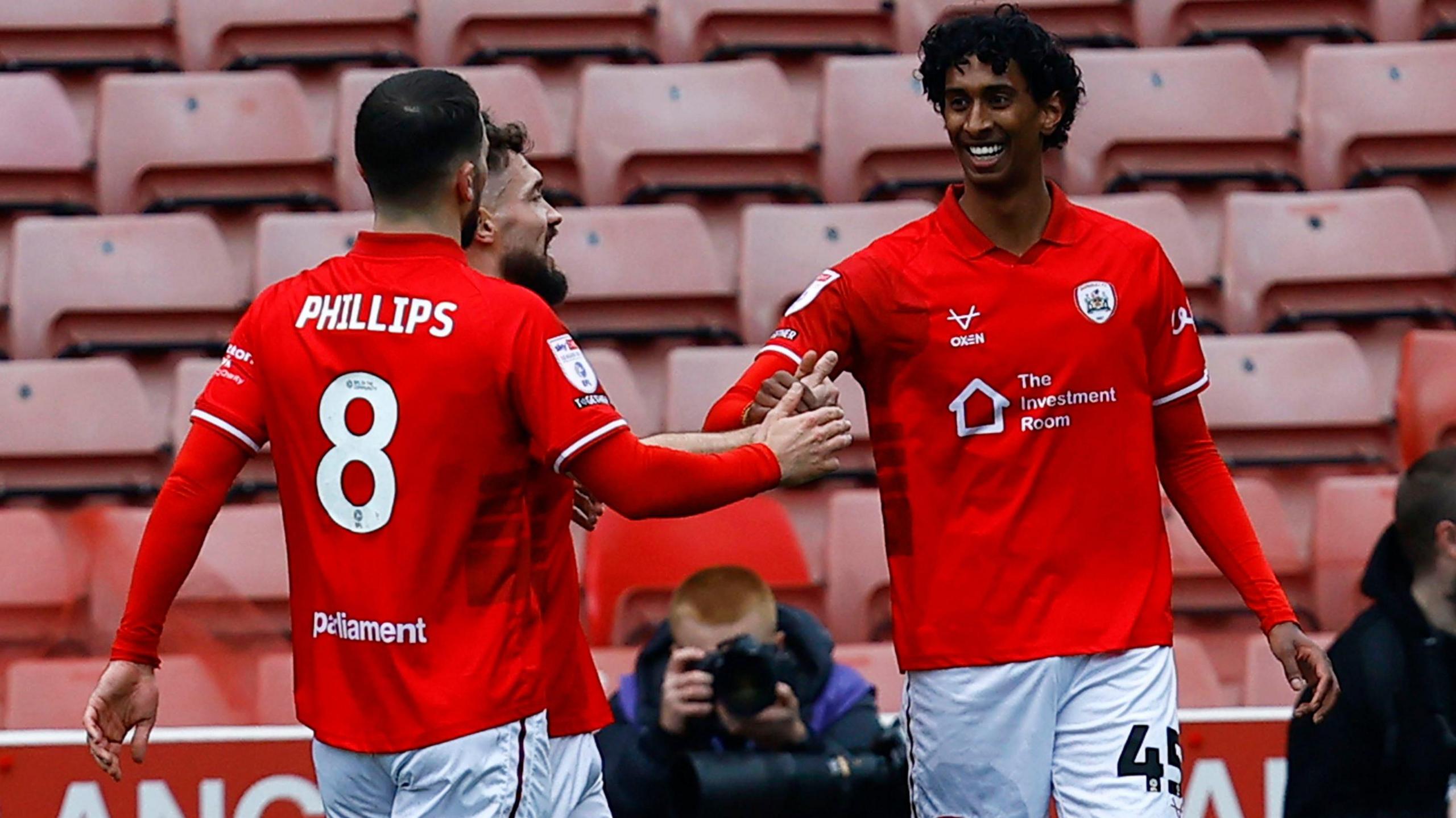 Vimal Yoganathan is congratulated by team-mates after scoring for Barnsley