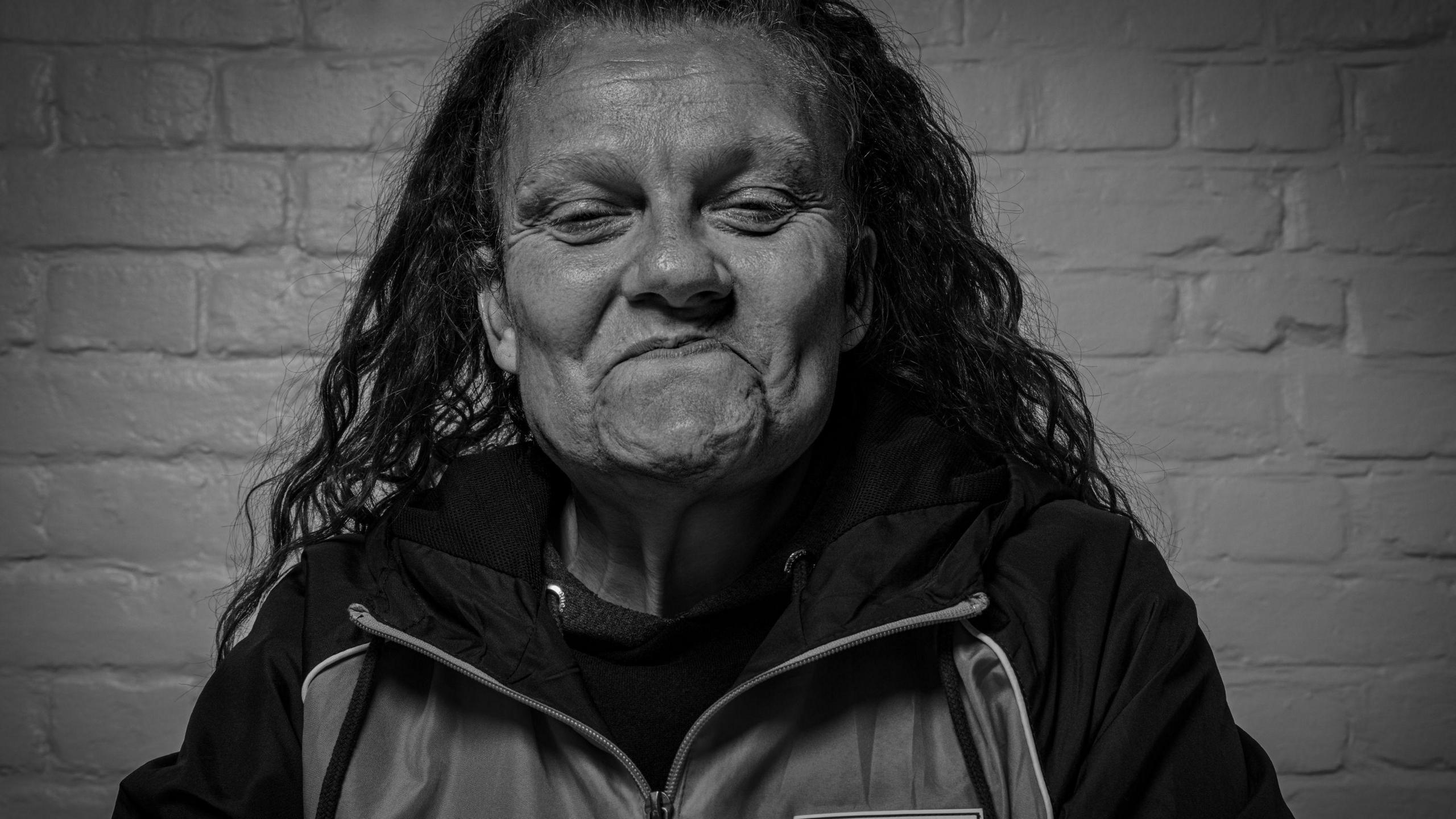 Black and white close up photo of a homeless person smiling