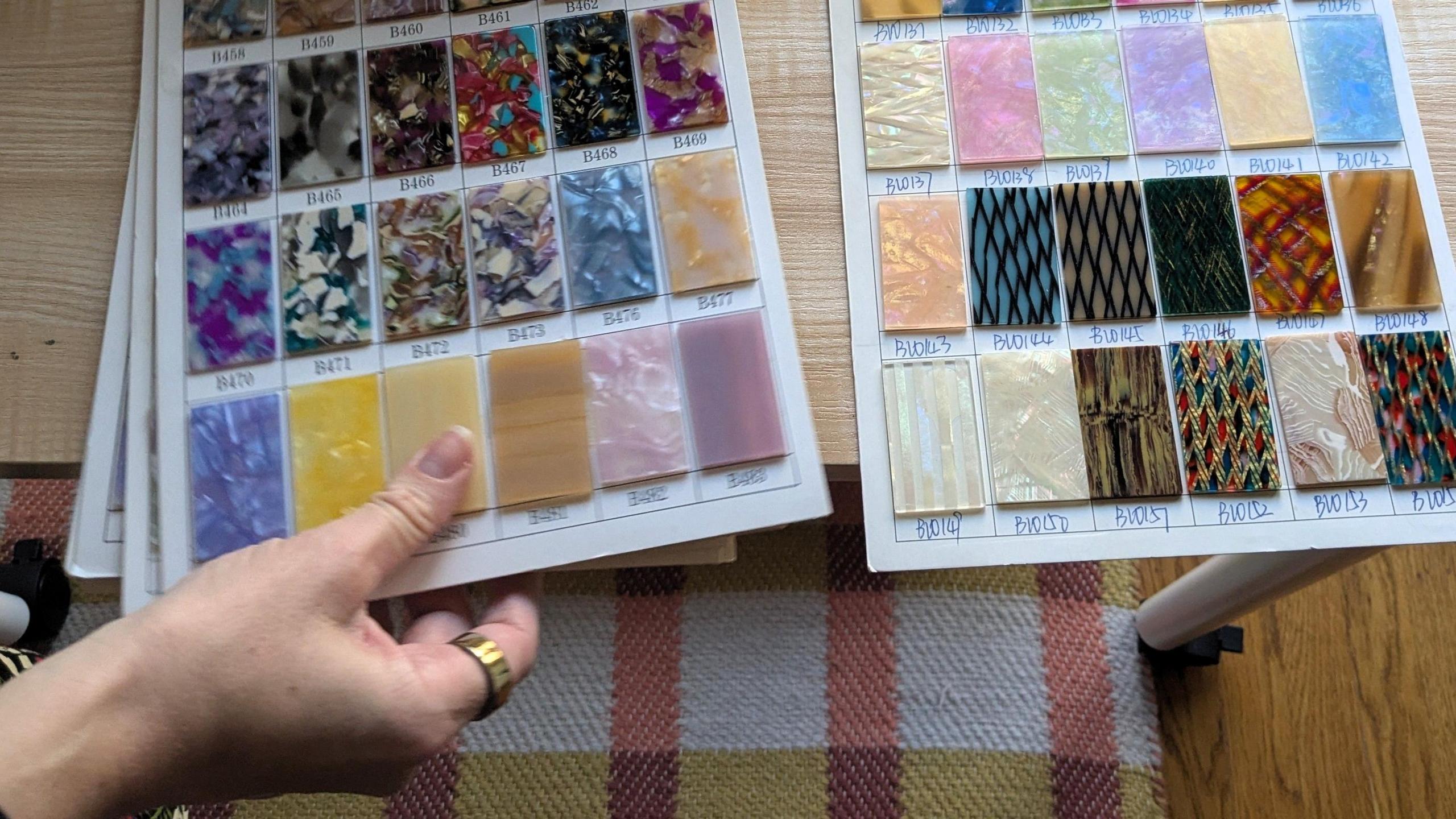 Jenny Lennick showing a book of sample cellulose acetate colours