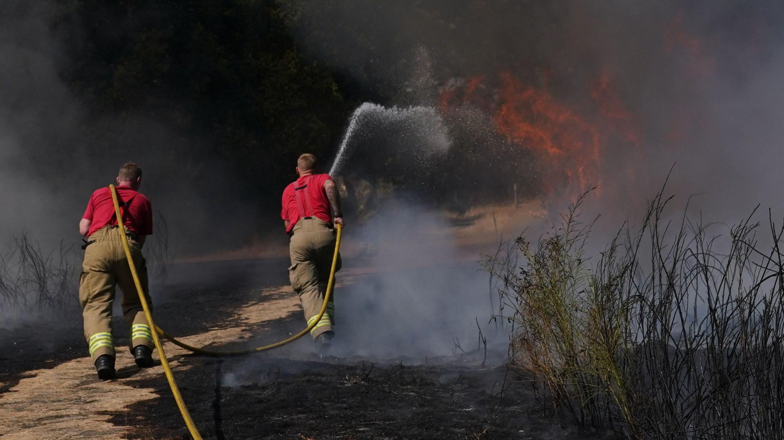 Firefighters battle a grass fire on Leyton flats in east London in August 2022