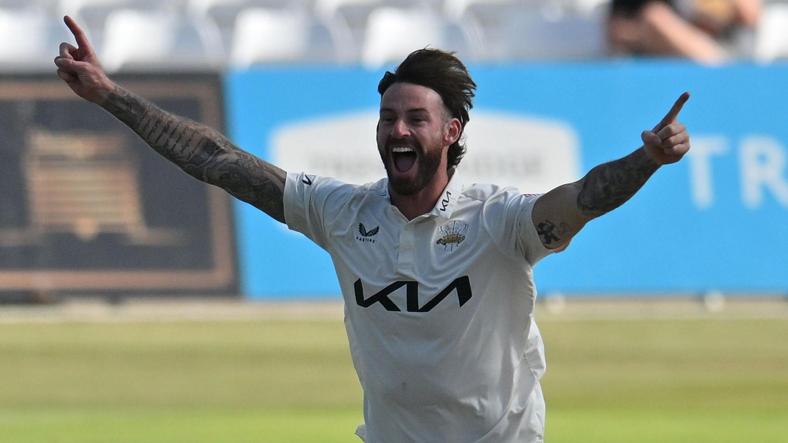 Jordan Clark celebrating taking a wicket for Surrey.