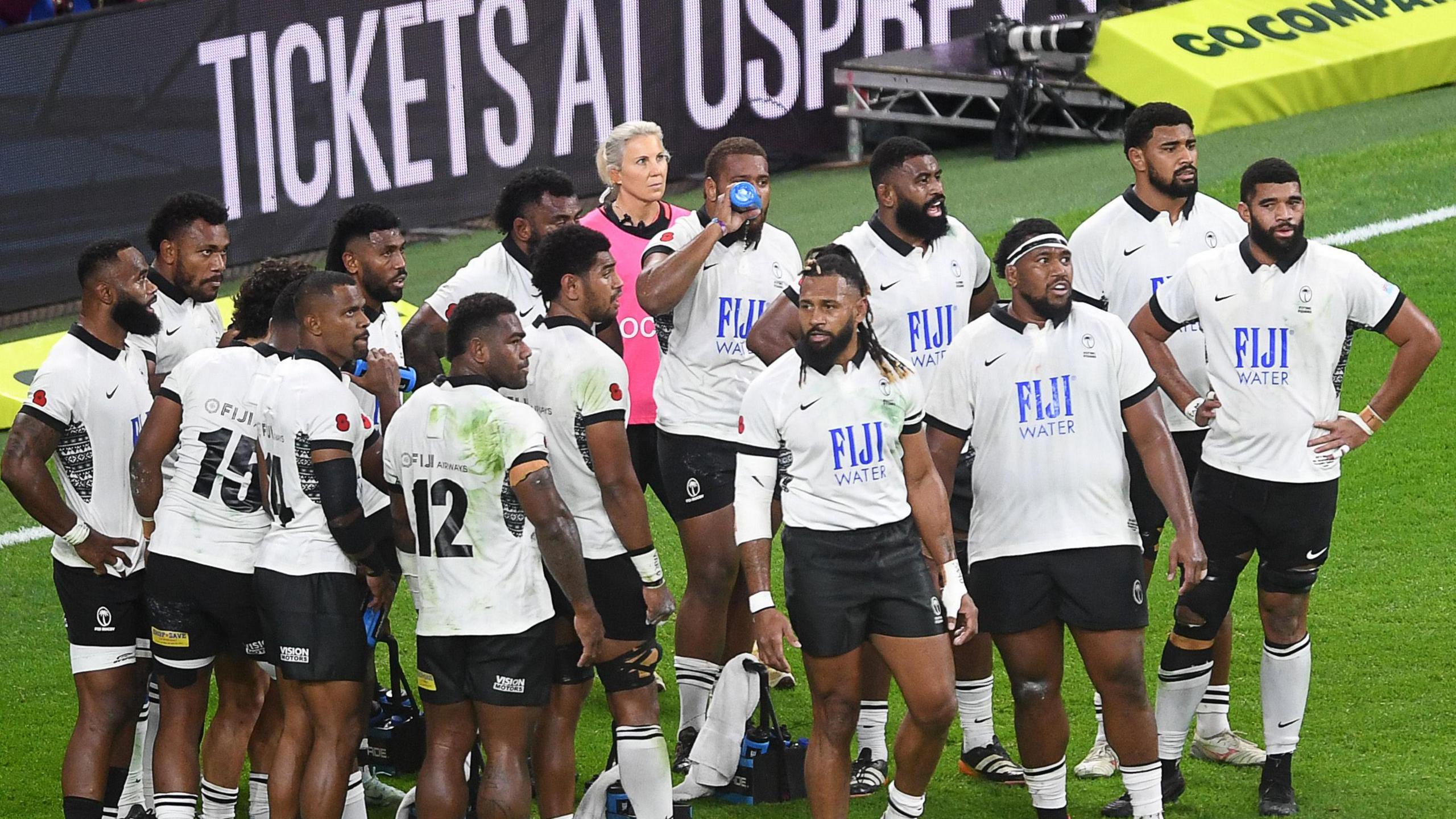 Group of Fiji players in black and white kit on the field in 2024
