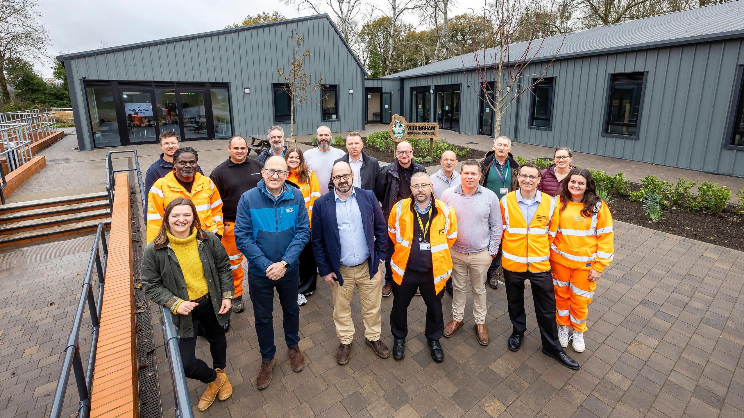 Wokingham Borough Council staff and partners in front of their new offices at Toutley Depot. Some are wearing high vis outfits. It's an overcast day.