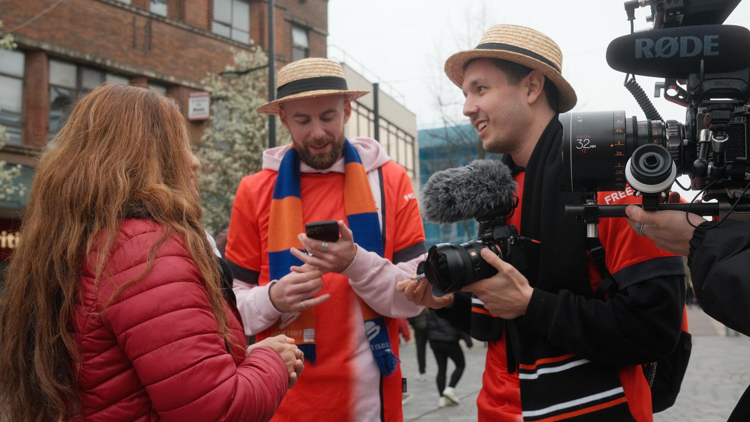 Yes Theory dressed in Luton football kit and filming in the town centre