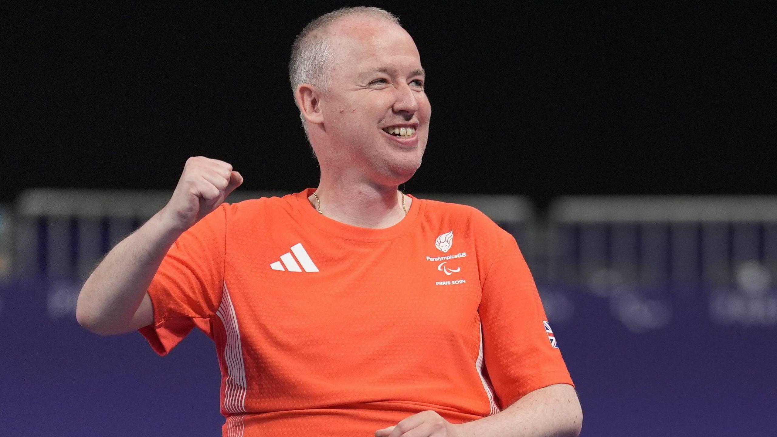 Stephen McGuire punches the air in celebration after winning a Paralympic gold medal in boccia