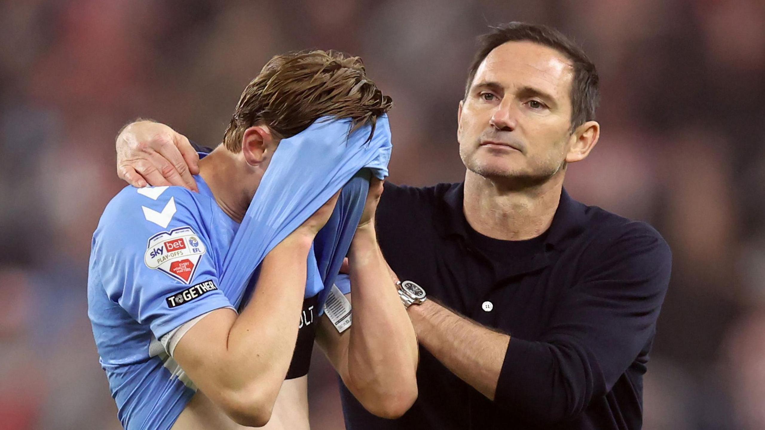 Jack Rudoni, with his shirt covering his face, is consoled by Frank Lampard after Coventry's play-off exit to Sunderland