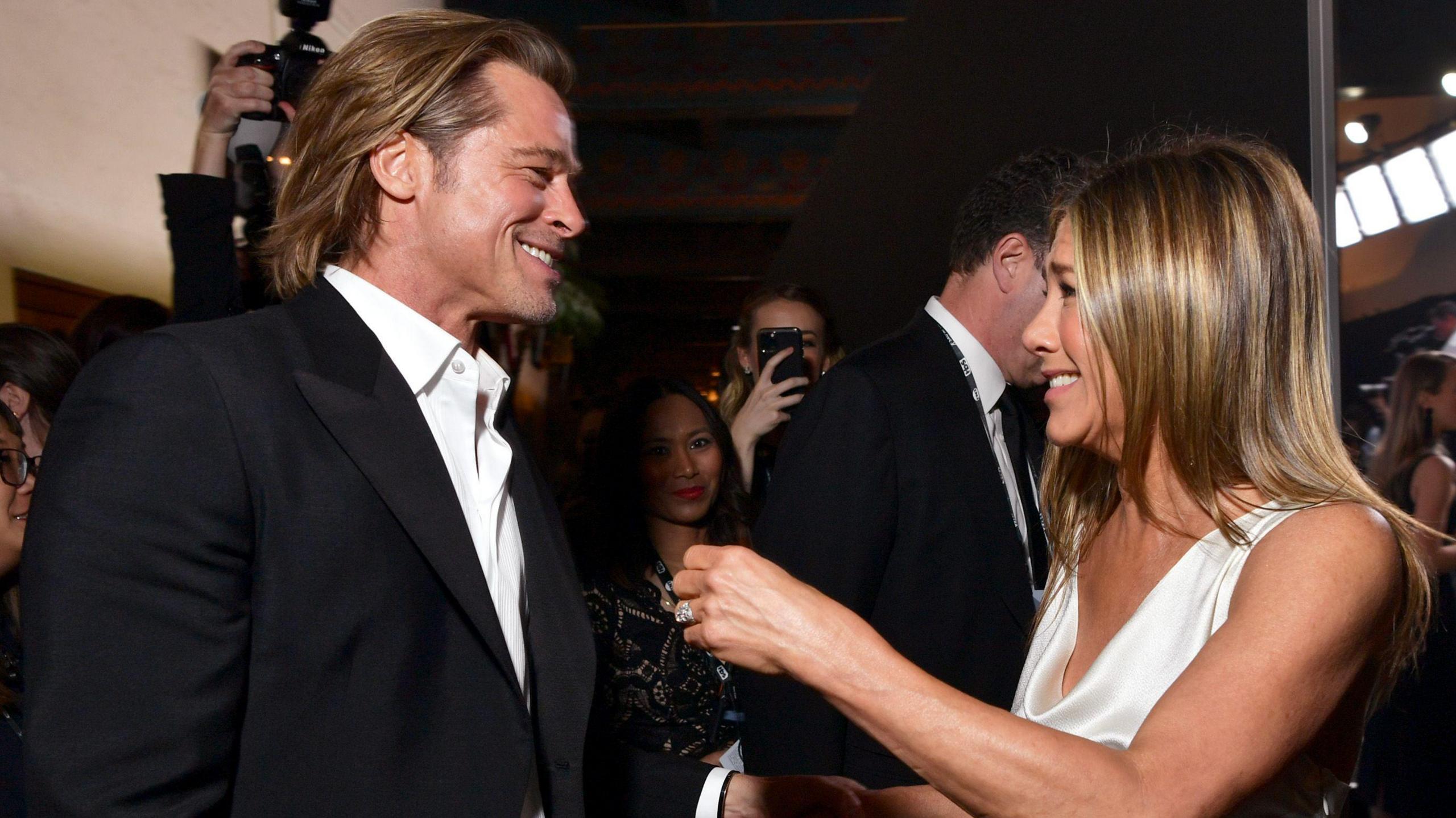 Both in smart clothes, Brad Pitt and Jennifer Aniston laughing together