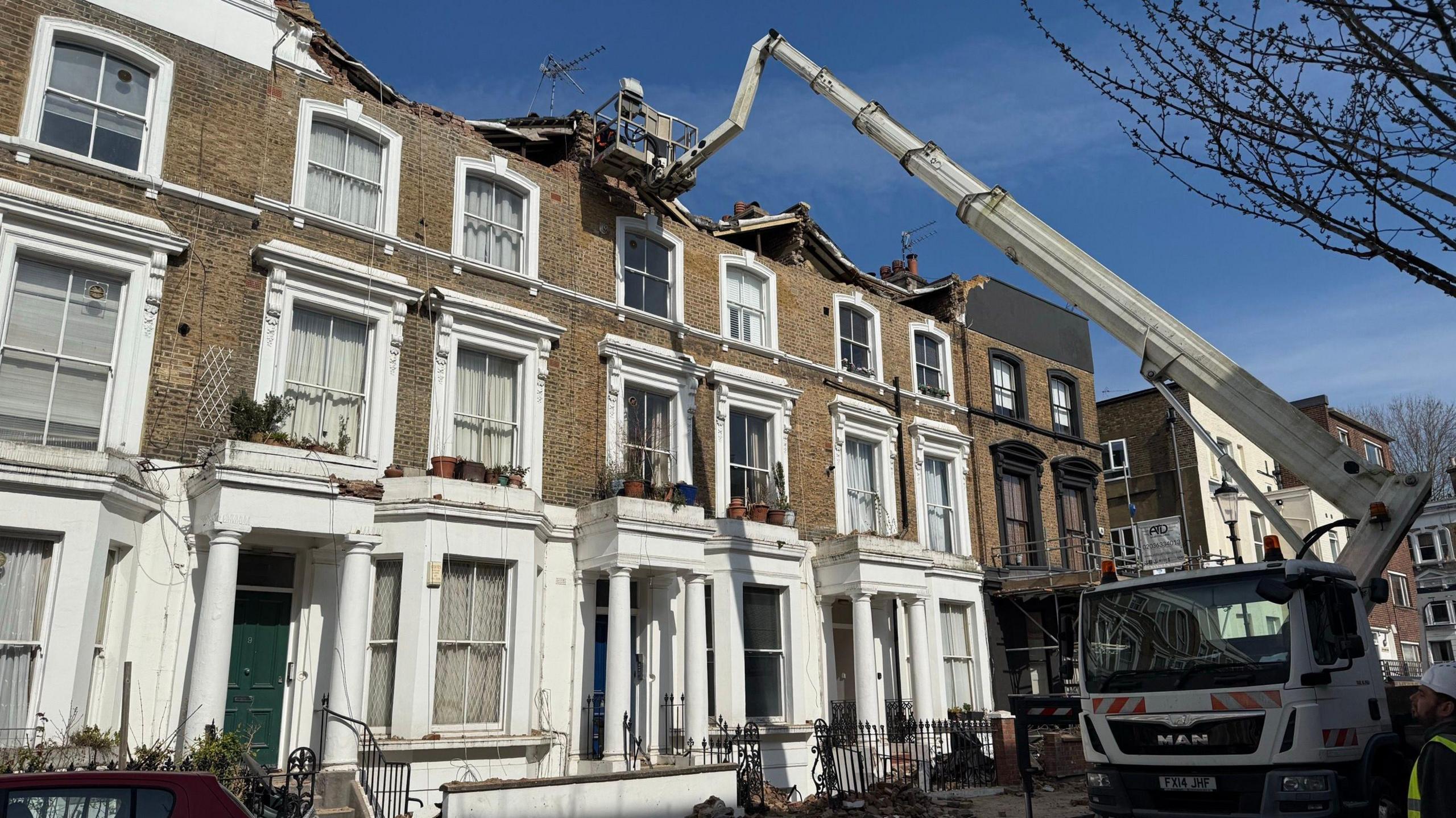 A worker stands on machinery to inspect the properties.