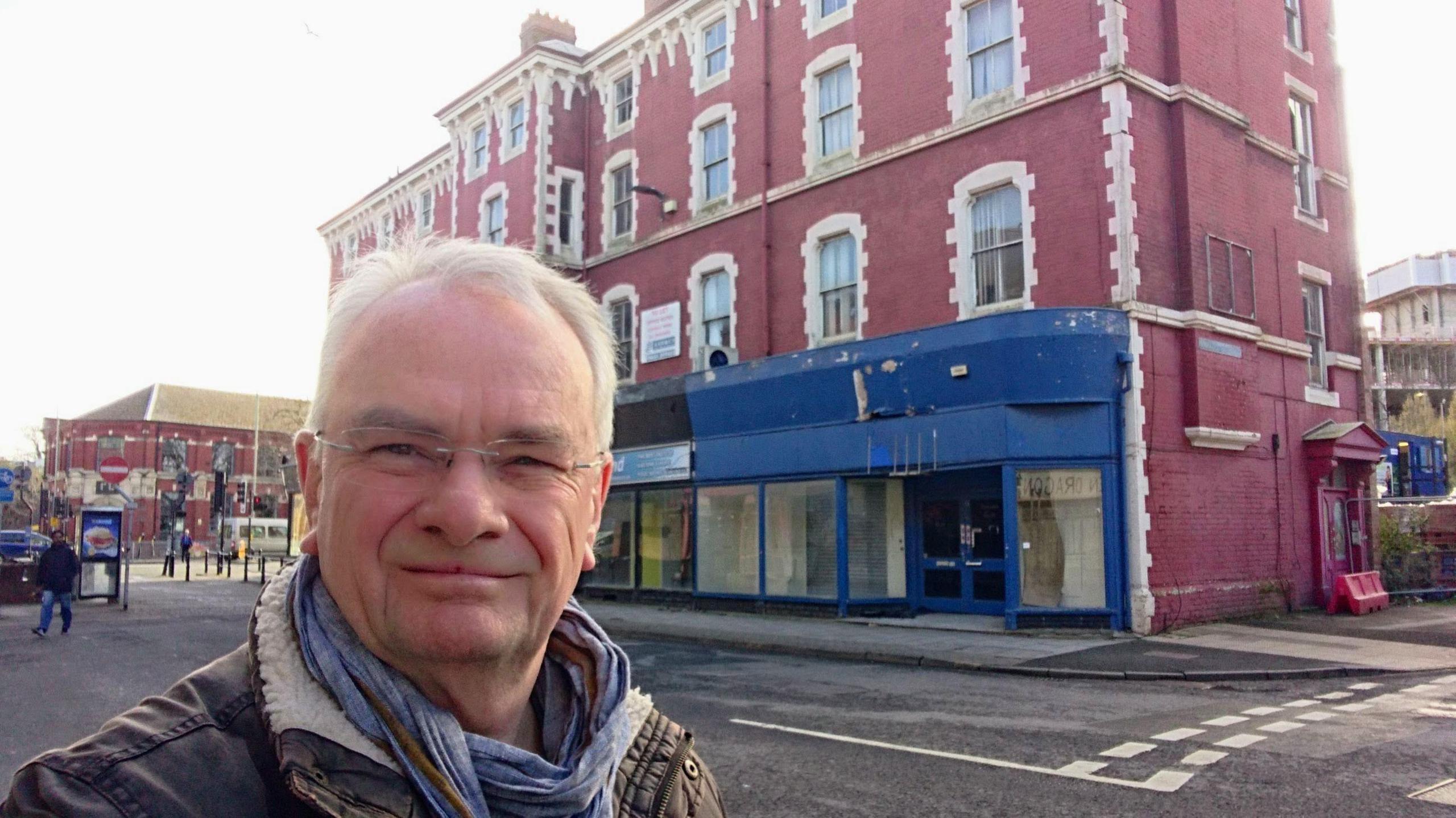 Gloucester City Council leader Jeremy Hilton stood on Northgate Street in Gloucester with a red Georgian building behind him, the bottom floor of which is empty retail space