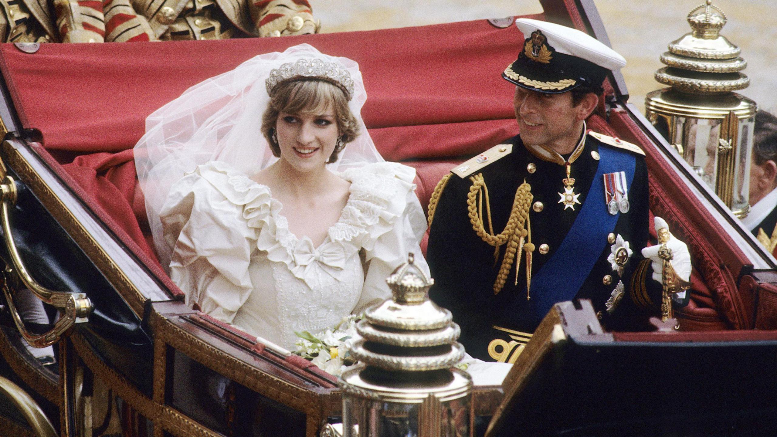 King Charles and Diana in her wedding dress on their wedding day in a chariot.