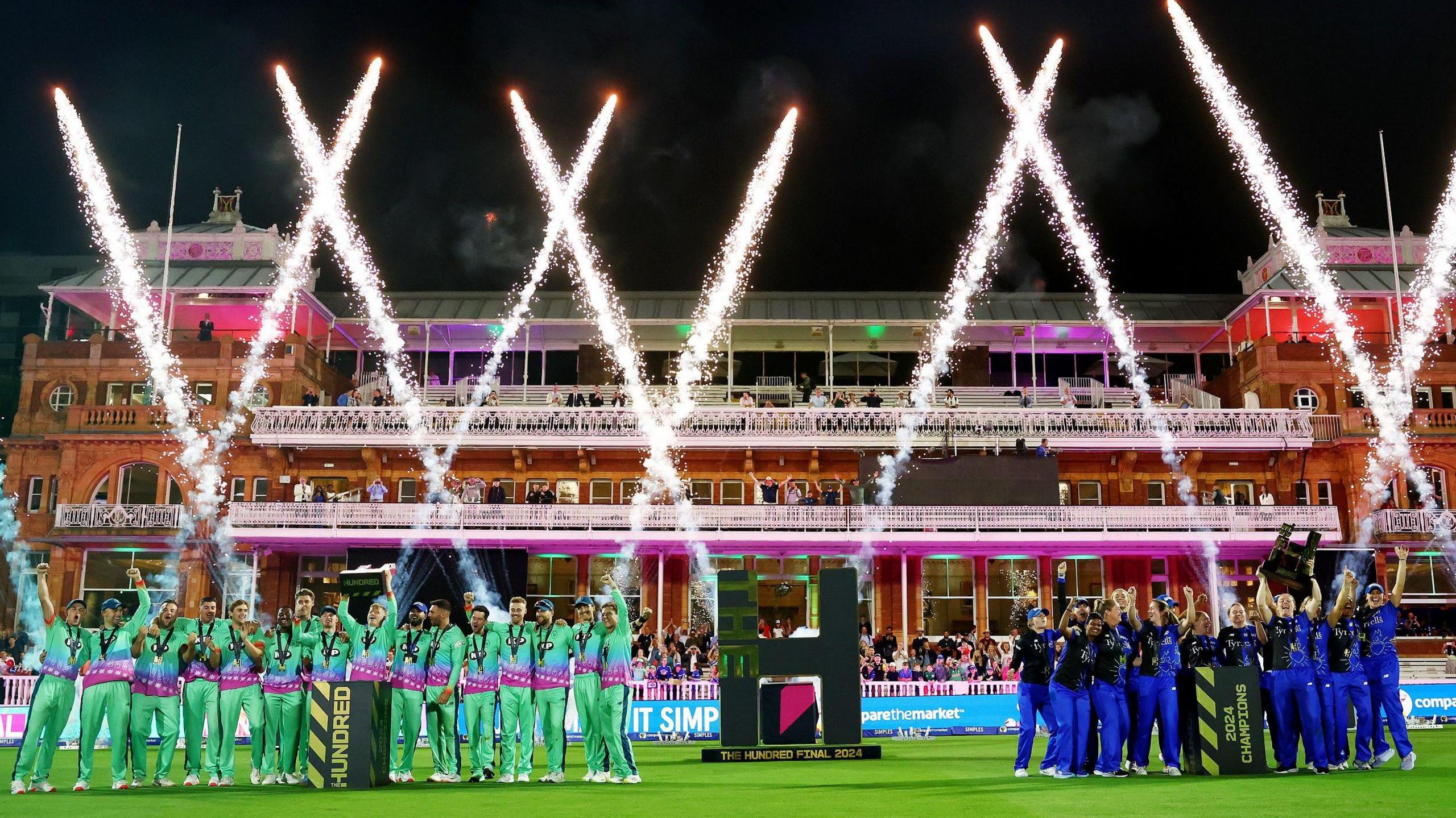 Players from London Spirit's men's team and Oval Invincibles' women's side lift The Hundred trophy at Lord's as fireworks go off in background