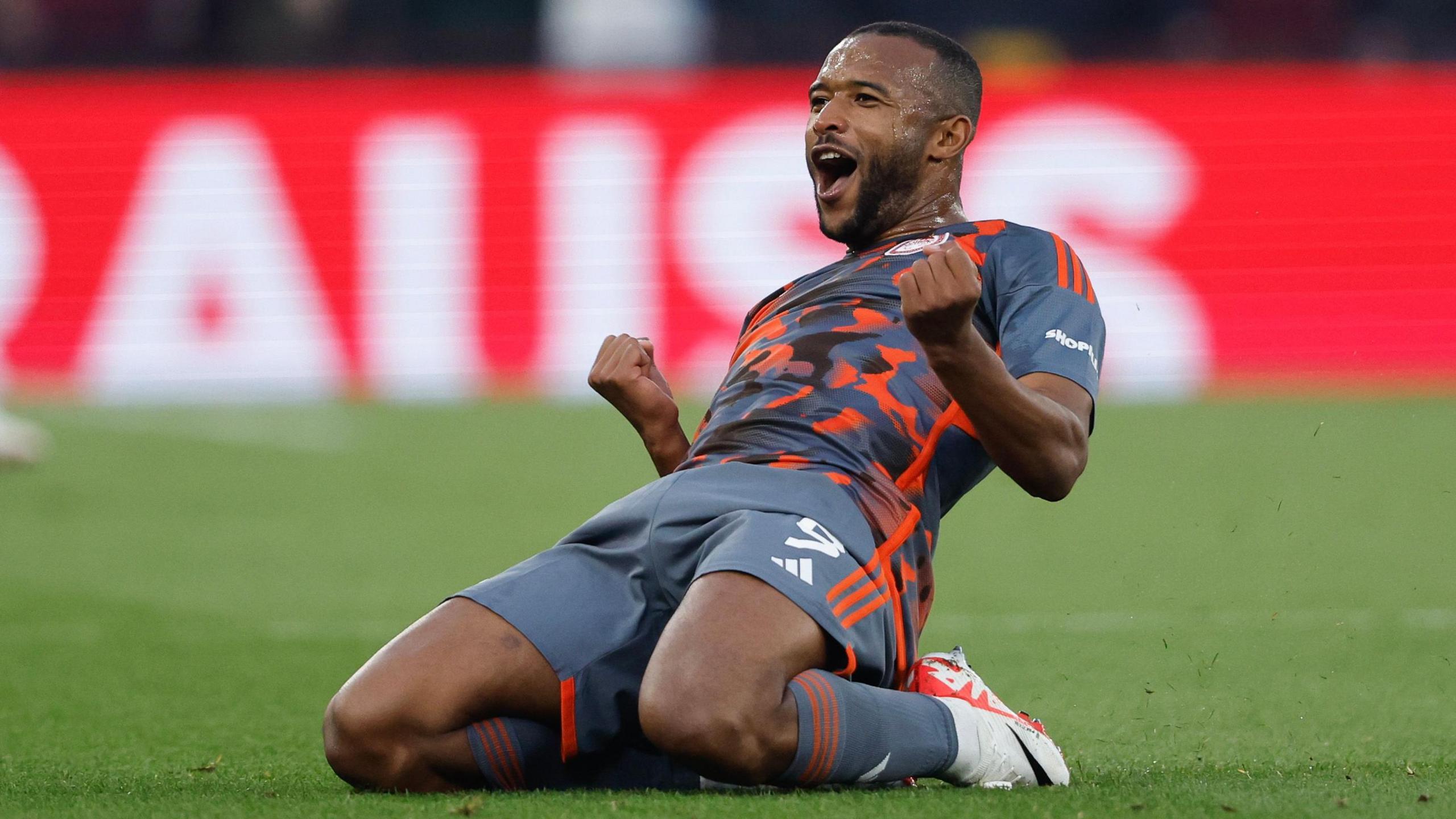 Ayoub El Kaabi slides on his knees as he celebrates a goal for Olympiakos