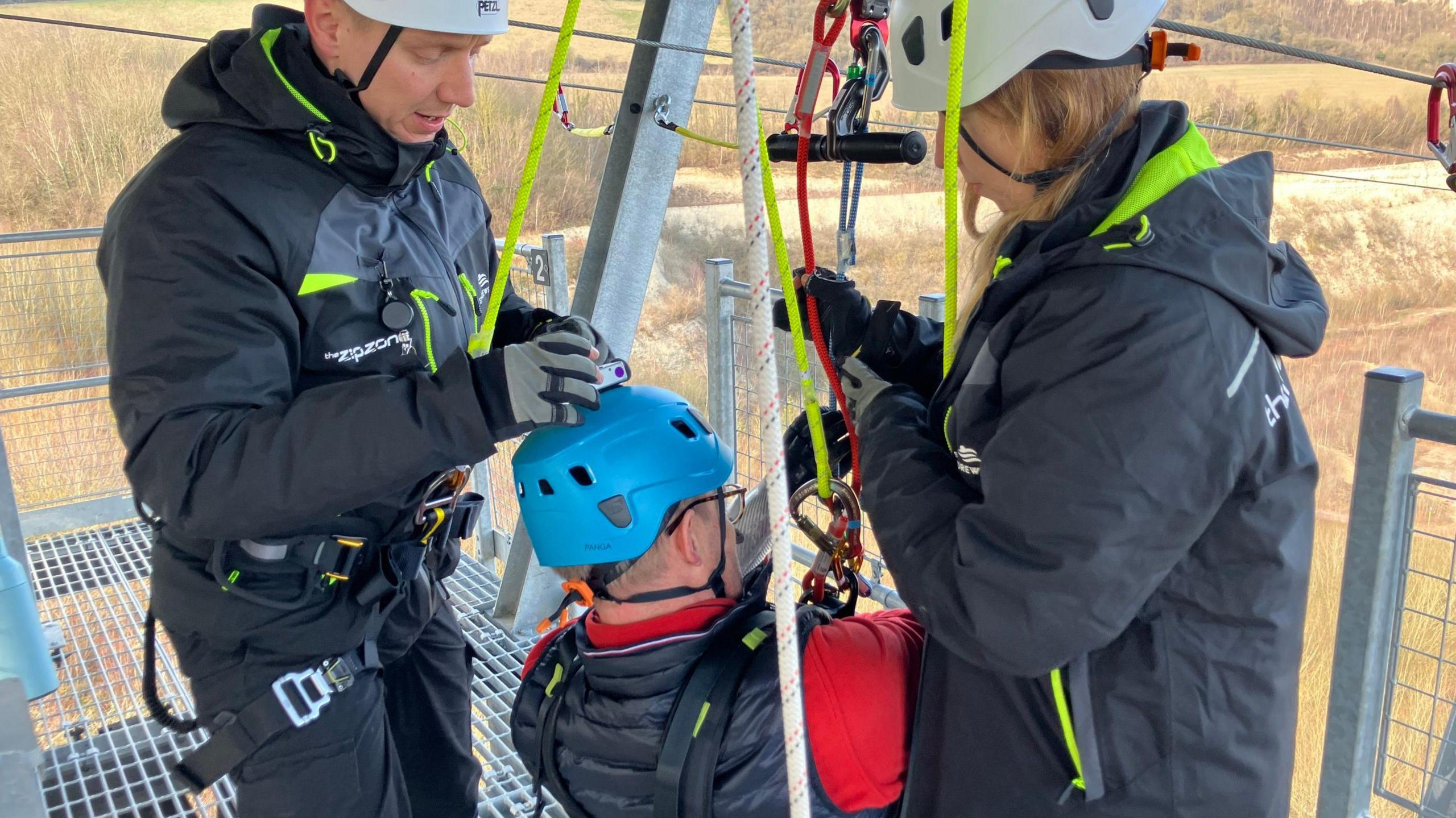 Lord Mackinlay of Richborough being fastened in on his zip wire