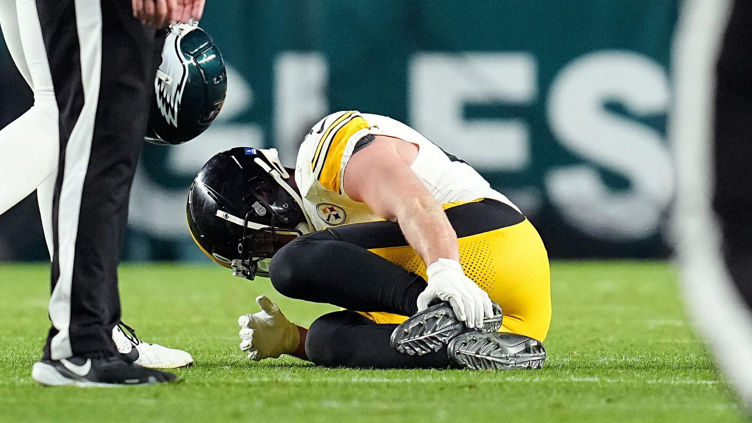 Pittsburgh Steelers star TJ Watt lies on the ground clutching his foot after being injured playing against the Philadelphia Eagles